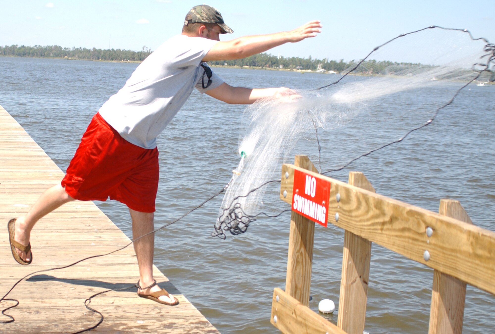 Kirk Mullins, 81st Supply Squadron, casts a net to gather bait for fishing during the birthday picnic at marina park, Sept. 19.  (U.S. Air Force photo by Kemberly Groue)