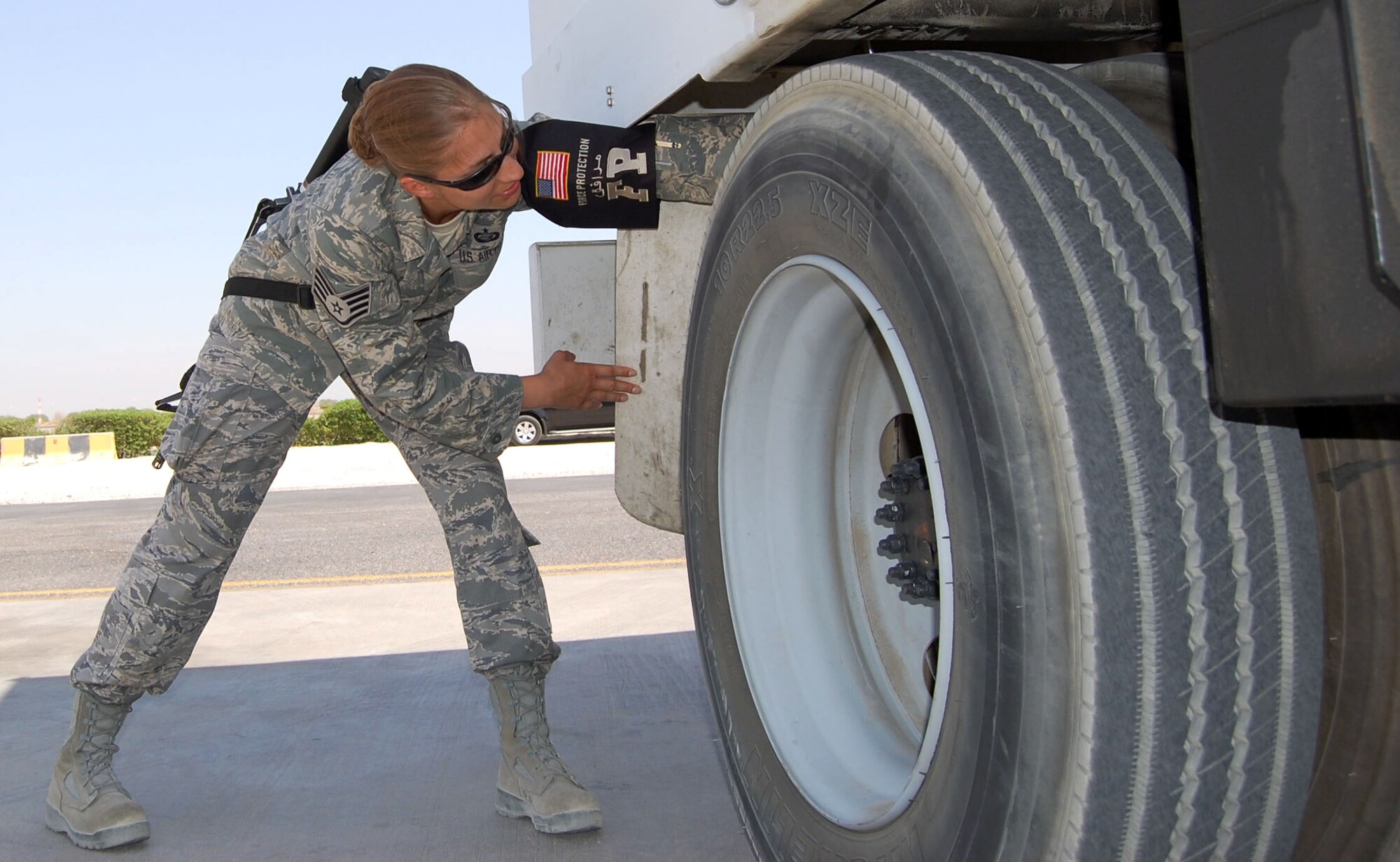 Staff Sgt. Amanda Sutton searches behind a wheel of air conditioning truck Sept. 25 at an undisclosed location in Southwest Asia. Sergeant Sutton is a 387th Expeditionary Support Squadron force protection specialist from Brooks City Base, Texas. (U.S. Air Force photo/Staff Sgt. Phillip Butterfield)