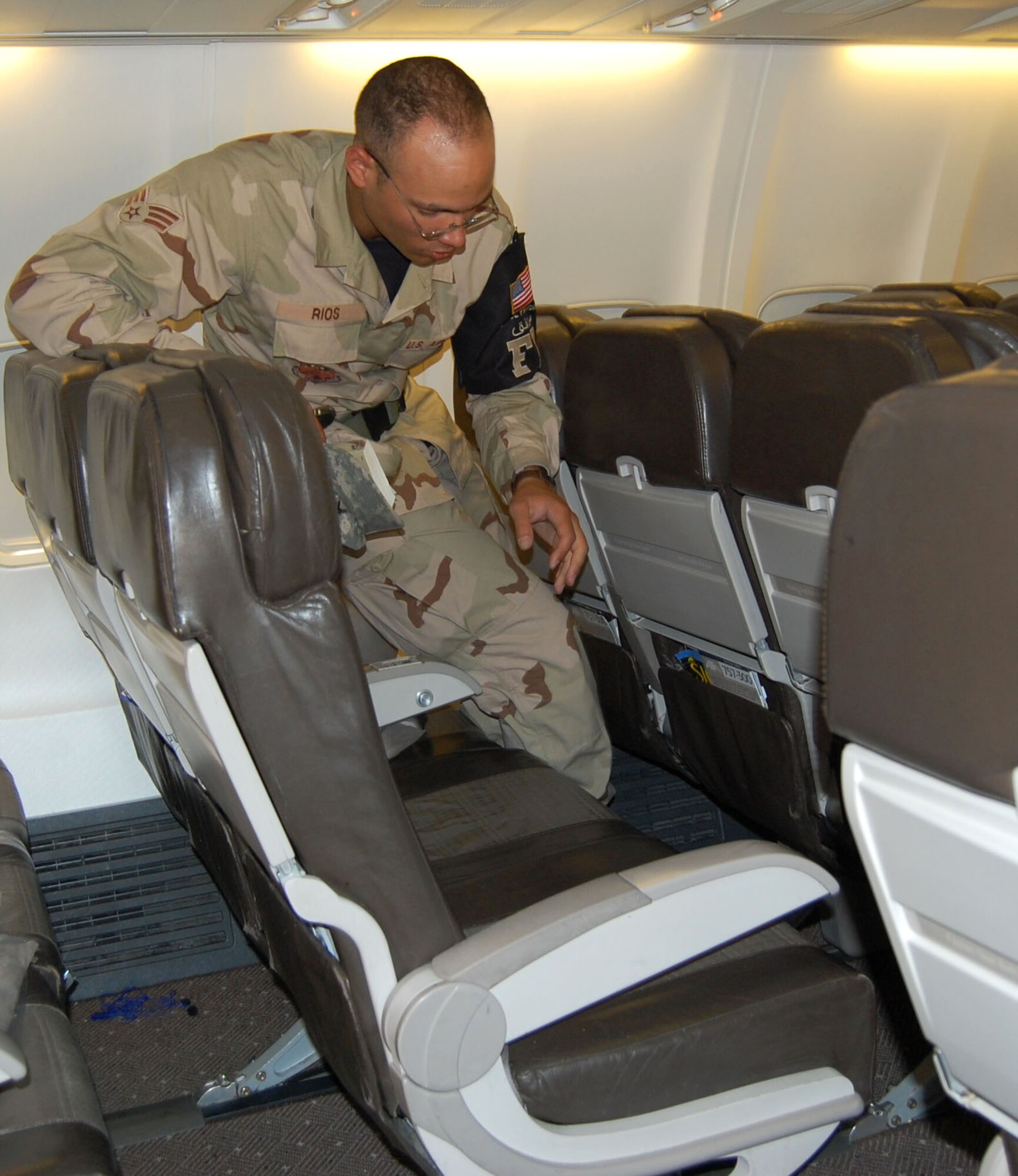 Senior Airman Tommie Rios searches aircraft seats for items left by passengers Sept. 25 in Southwest Asia. Airman Rios is a force protection specialist with the 387th Expeditionary Support Squadron in Southwest Asia. Airman Rios is deployed from Goodfellow Air Force Base, Texas. (U.S. Air Force photo/Staff Sgt. Phillip Butterfield) 