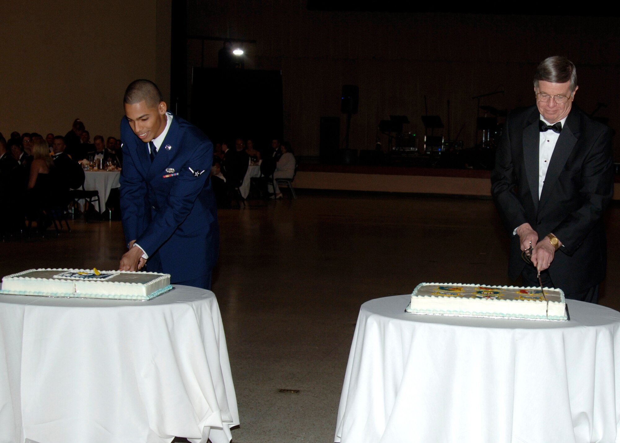 MCCONNELL AIR FORCE BASE, Kan. -- Airman Juvian Marquez, 22nd Logistics Readiness Squadron, and Retired Lt. Gen. Phillip Ford participate in the cake cutting ceremony during the 60th Anniversary Air Force Ball, Sept. 15, at the Century II Convention center, Wichita. Traditionally, the cake is cut the lowest and highest ranking two people in attendance. (photo by Airman 1st Class Justin Shelton)