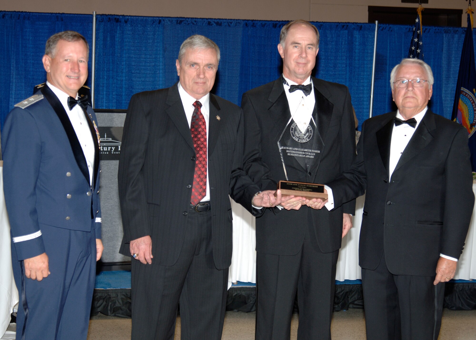 MCCONNELL AIR FORCE BASE, Kan.  -- Maj. Gen. Fred Roggero, Director of Air, Space, and Information Operations Headquarters, Air Mobility Command, presents the Zachary and Elizabeth Fisher Distinguished Civilian Humanitarian Award to Keith Lesher, Friends of McConnell president, Jack Pulley, McConnell Golden Eagle, and Bob Dool, McConnell Golden Eagle, during the 60th Anniversary Air Force Ball, Sept. 15 at the Century II Convention center, Wichita. The award is given yearly among each military service to an individual or organization recognized for exceptional patriotism and humanitarian concern for members of the United Stated Armed Forces or their families. (photo by Airman 1st  Class Justin Shelton)