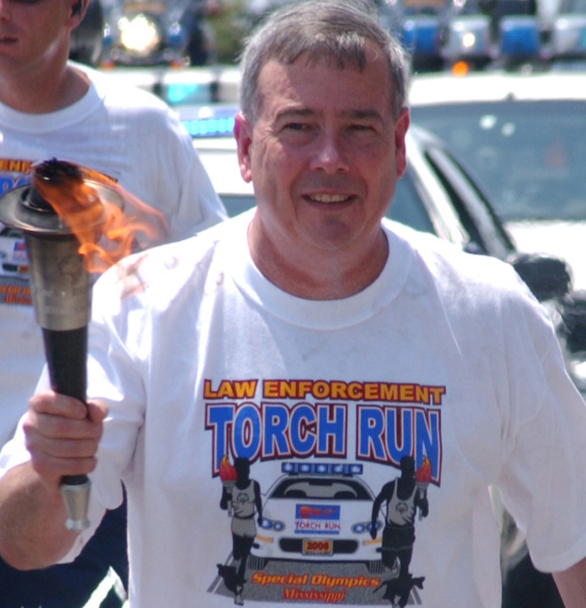 The general carries the torch onto the base for the 22nd Mississippi Special Olympics Summer Games in 2006.  (U.S. Air Force photo by Kemberly Groue)