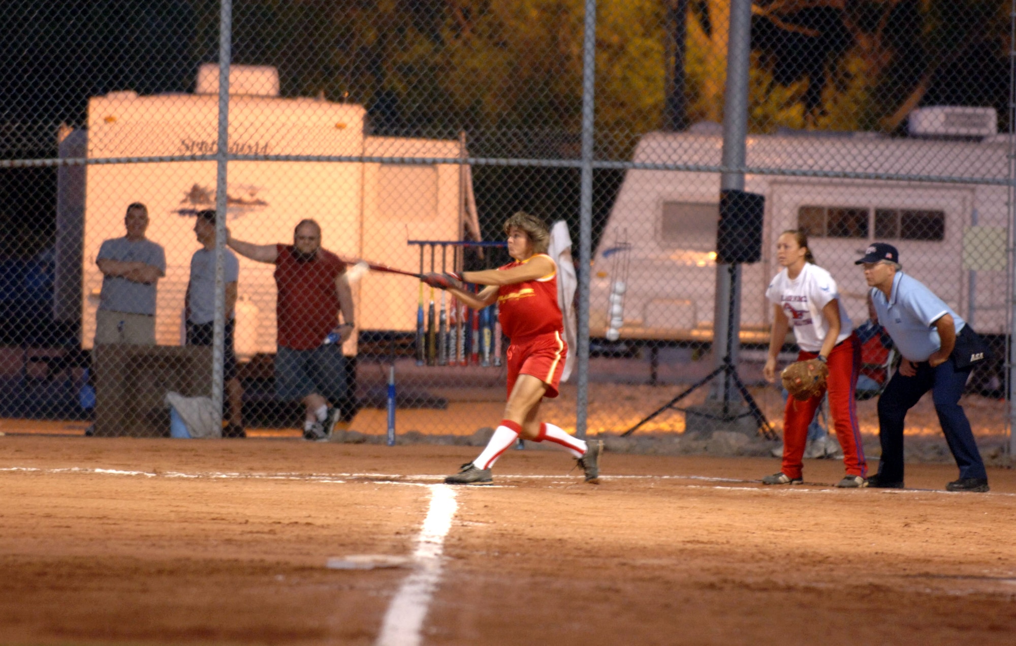 Marine Corps Capt. Trish Ruf gets a hit during recent softball action as Senior Airman Carly Edwards looks on Sept. 20 at Hill Air Force Base, Utah. The Air Force team won the All-Armed Forces Women's Softball Championships. (U.S. Air Force photo by Alex R. Lloyd) 
