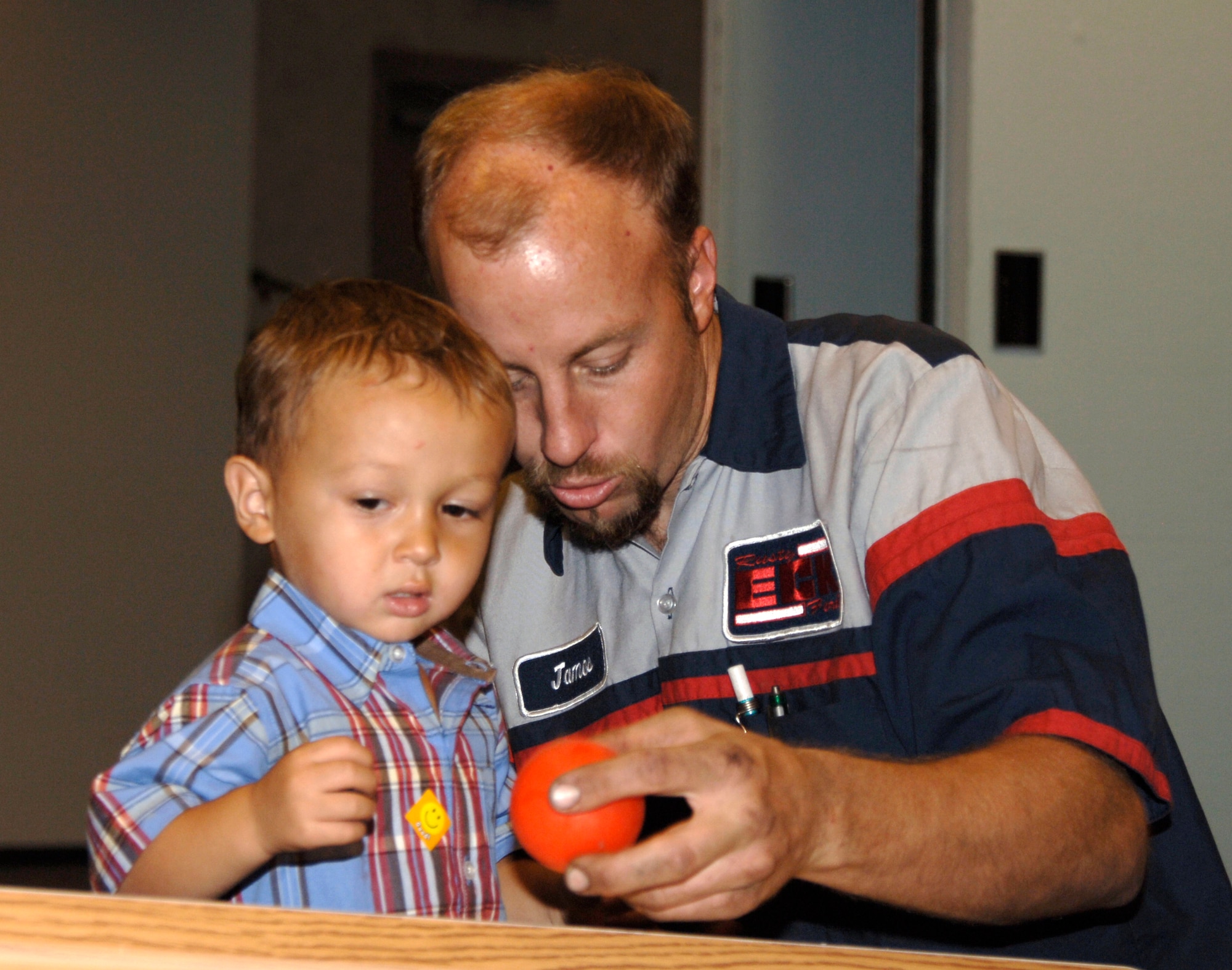 MCCONNELL AIR FORCE BASE, Kan. -- Mr. James Vorderlandwehr and son Isaac, 2, play with a ball at the McConnell Game Night Sept. 21 at the Robert J Dole Community center ballroom. Isaac was one of many children who enjoyed himself playing activities such as video games, basketball toss, cards, pool, computer based games, and a portable gaming system competition. (photo by Airman 1st Class Laura Suttles) 
