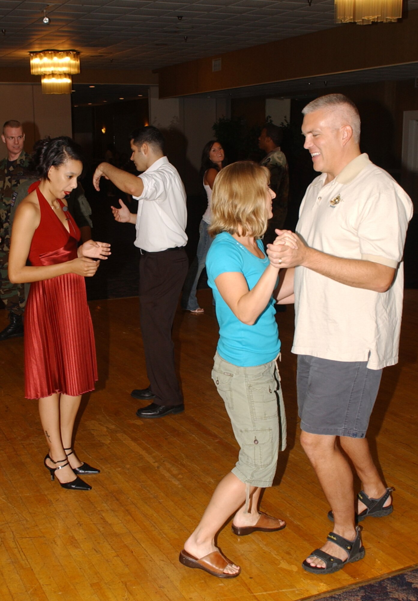 Lt. Col. Jeffrey Granger, 14th Communications Squadron commander, and his wife, Sheryl, learn to salsa dance during “Salsa Night at the Club” as Senior Airman Cynthia Vazquez, 14th CS, looks on Sept. 14 after assignment night at the Columbus Club. (U.S. Air Force photo)