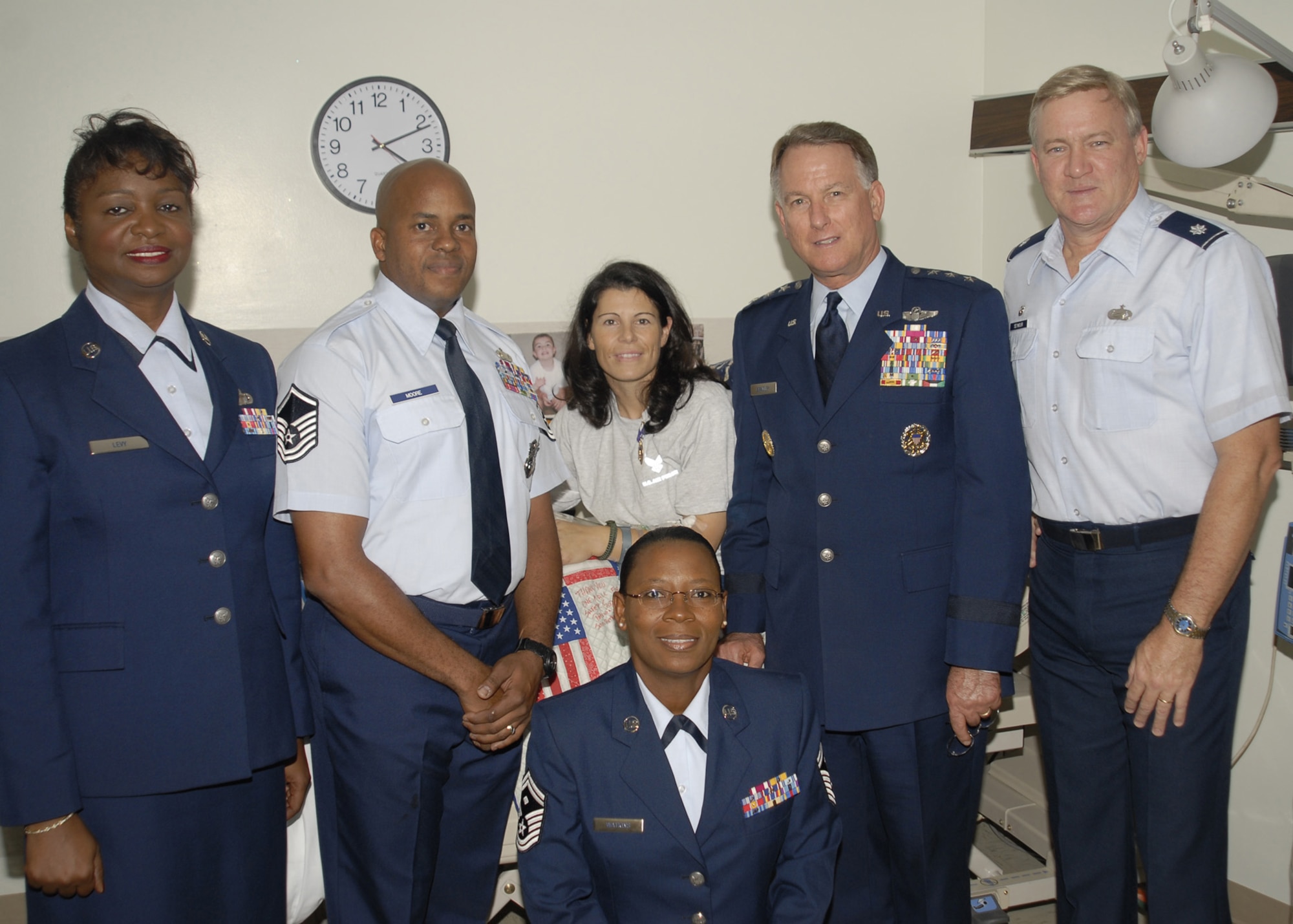 Air Force Reservist Senior Airman Diane Lopes (center) poses with Chief of the Air Force Reserve Command, Lt. Gen. John A. Bradley (right of Airman Lopes) and 920th Rescue Wing senior leadership, after receiving the Purple Heart bedside.  General Bradley presented the medal Sept. 28 to Airman Lopes in her hospital room at Walter Reed Army Medical Facility in Maryland.  Airman Lopes is a security forces apprentice with the 920th RQW, Patrick AFB, Fla.  She is in good condition and on the road to recovery despite surviving a mortar attack a week ago at Kirkuk AB, Iraq.  She and her fellow 920th RQW security forces comrades were in Iraq less than a month when Airman Lopes was struck by enemy shrapnel in the right arm and left leg while walking on base after a mortar attack. She was off duty at the time. Officials say her prognosis is good, but she has a lot of physical therapy ahead of her. (U.S. Army Photo/Winston S. Wilson)