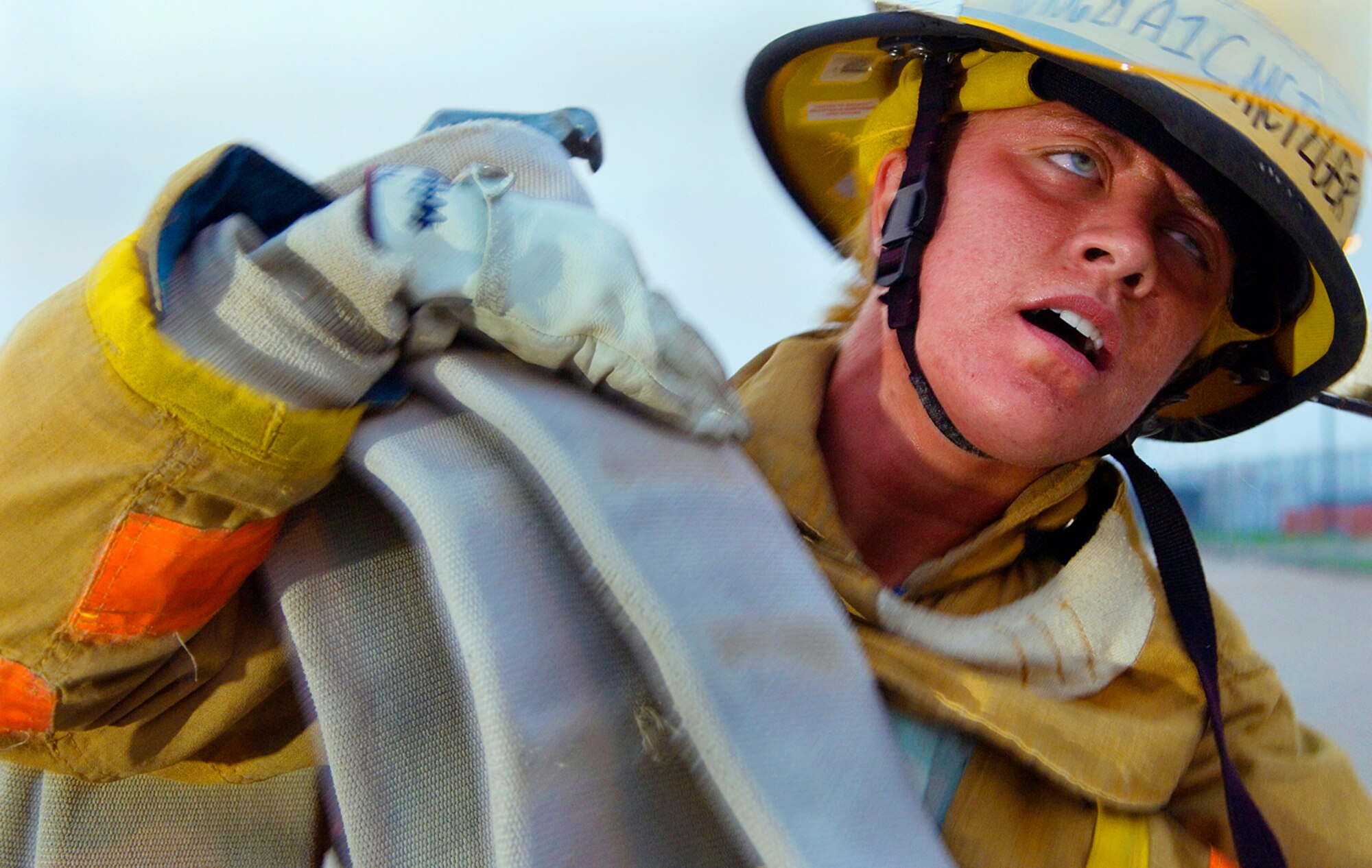 Nearing the point of exhaustion, Airman 1st Class Erin Metzger of the Pennsylvania Air National Guard drags the dead weight of 150-pound fire hose in the heat of a Texas summer day. The 300-foot hose drag is one of many physical challenges students have to overcome to graduate from the firefighting school. (Photo by Tech. Sgt. Matthew Hannen)
