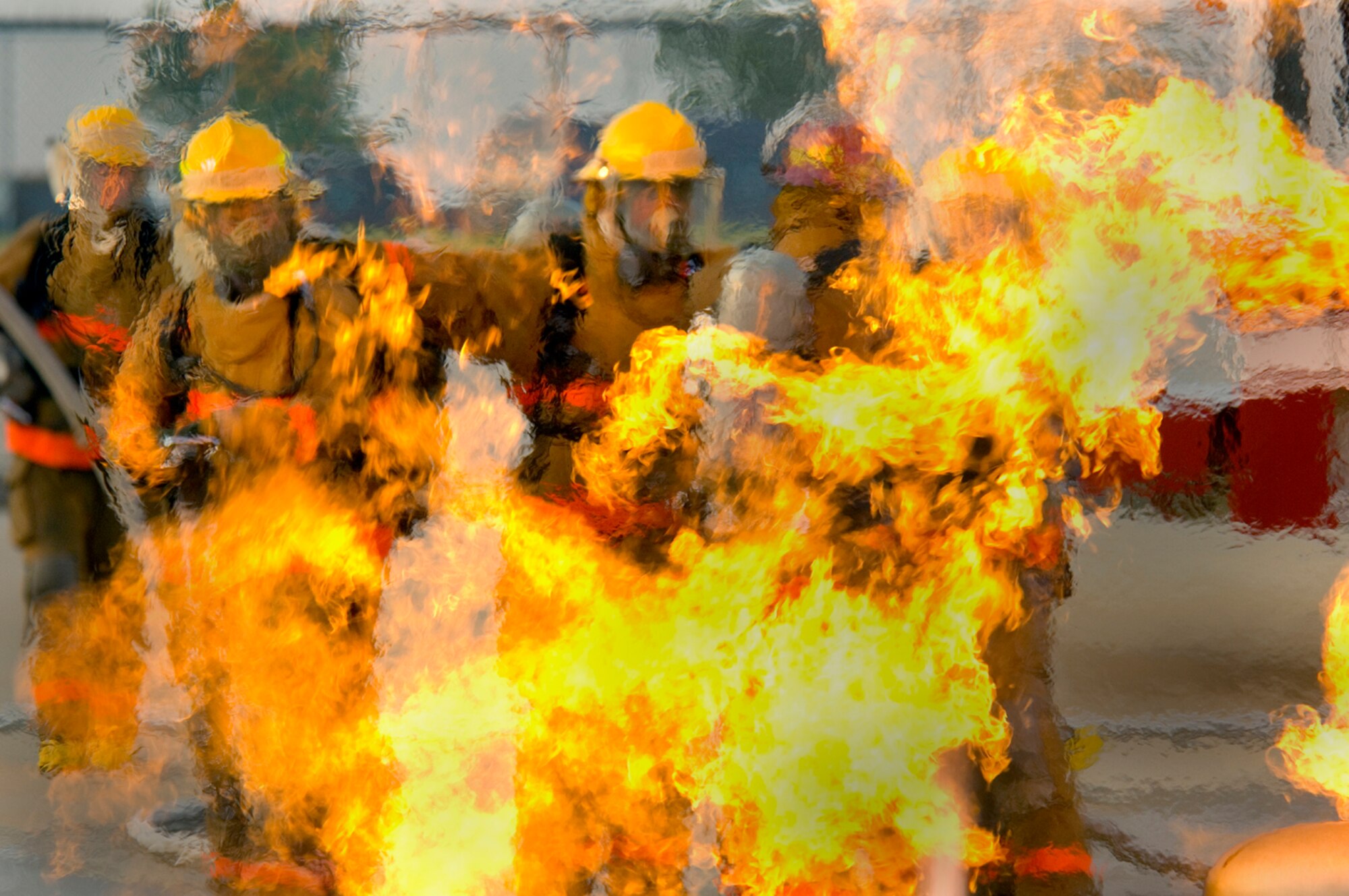 Flame on! From left to right, Army pvt. David Valadez, Airman Basic Anthony Haddock, and Airman 1st Class Alan Knabe work hard to put out a fuel fire, while receiving instruction from Marine Staff Sgt. George Vargas. The Louis F. Garland Department of Defense Fire Training Academy at Goodfellow AFB, Texas, trains students in proper hose techniques so they can attack a fire swiftly, aggressively, effectively and as safely as possible. (Photo by Tech. Sgt. Matthew Hannen)