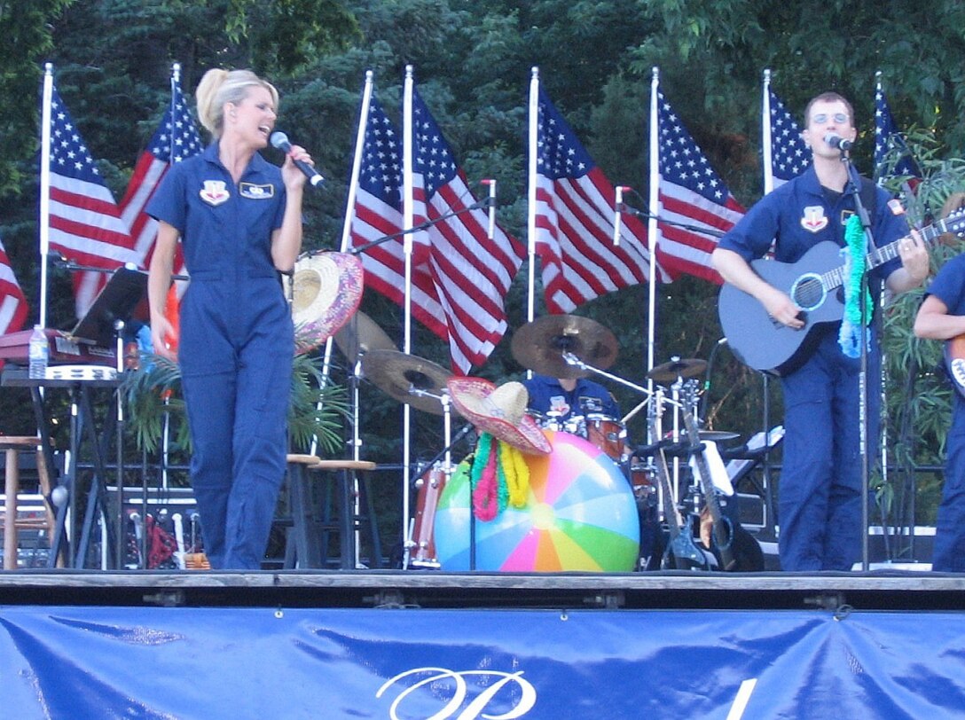 TSgt Lara Murdzia and SSgt Clint Whitney perform with the USAF Heartland of America Band's pop/country music group, Night Wing, as part of their "Beach Party"-themed summer concert.  This performance was a part of the band's 'Sunday's on Parade' summer concert series at Offutt AFB.