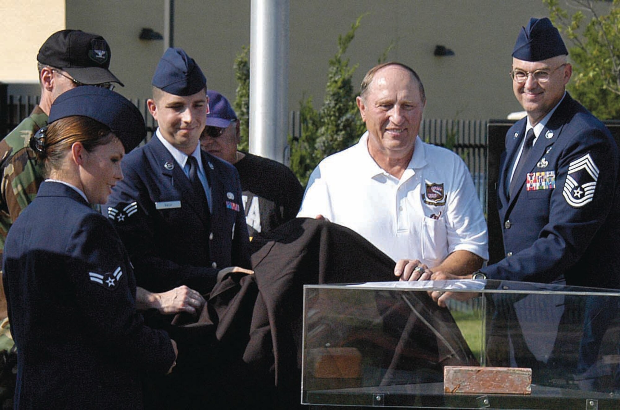 A brick from the Vietnam War prisoner of war camp known as “Hanoi Hilton” was dedicated at the POW/MIA section of the Tinker Airpark Sept. 21.  Unveiling the brick are, from left; Airman 1st Class Stephanie Harrison, POW/MIA committee president; Col. Brad Ashley, Oklahoma City Air Logistics Center vice commander; Senior Airman Lawrence Bach, committee vice president: Dan Campos, committee member who donated the brick; special guest, former prisoner of war and Air Force retired colonel Leroy Stutz; and Chief Master Sgt. Randy Voigtschild. (Air Force photo by Margo Wright)