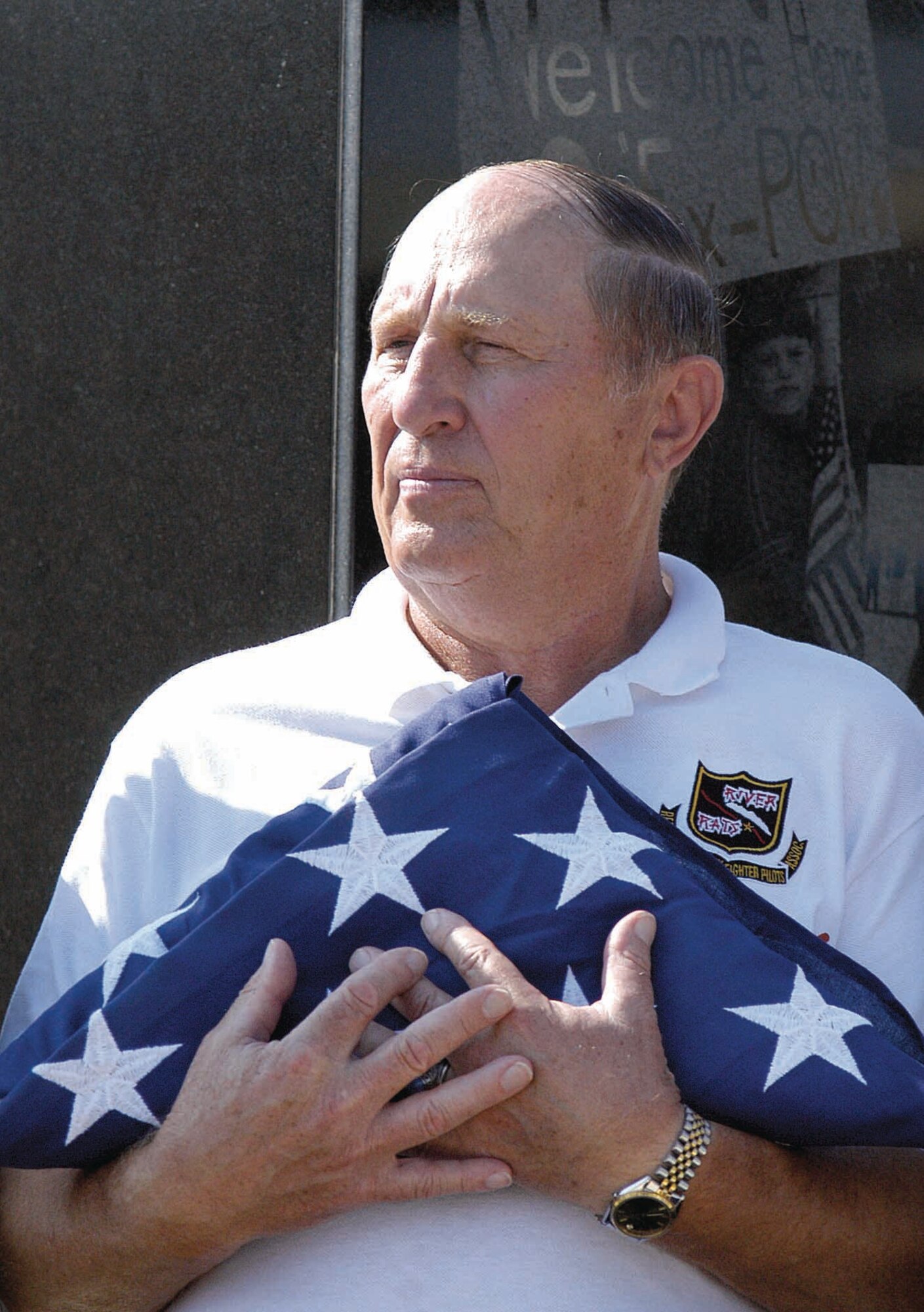 Retired Air Force Col. Leroy Stutz cradles an American flag presented to him during a Sept. 21 ceremony at the POW/MIA section of the Tinker Airpark.  Colonel Stutz was held as a prisoner of war for more than six years in the “Hanoi Hilton” during the Vietnam War. He recalled memories of that time during his presentations at the POW/MIA breakfast and during the dedication ceremony. (Air Force photo by Margo Wright)
