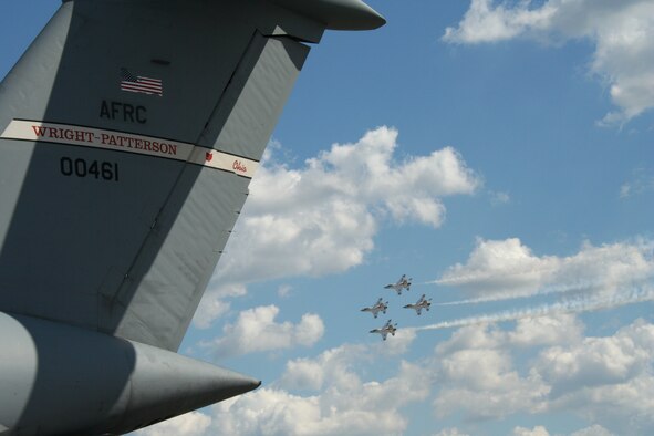 Rickenbacker Air National Guard Base, Columbus, Ohio -- Air Force Thunderbirds aerobatic team fly by the tail of a C-5 Galaxy aircraft from the 445th Airlift Wing from Wright-Patterson AFB, Ohio during the Gathering of Mustangs and Legends air show Friday, September 28, 2007. (U.S. Air Force photo/Maj. Ted Theopolos)