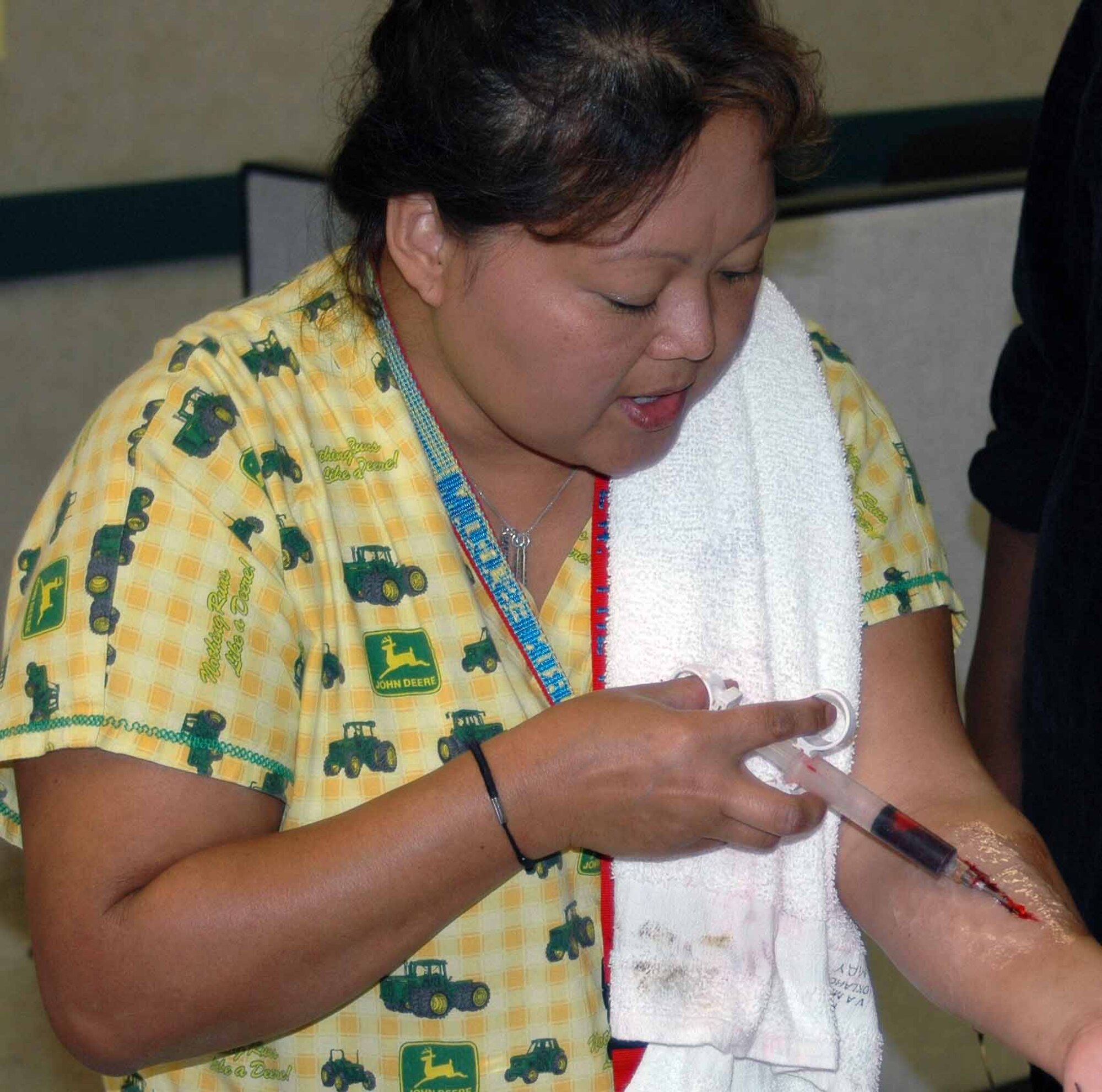 Sunny Schones, 72nd Medical Group clerk injects blood into her latex laceration while teaching a moulage training class on Sept. 19. She teaches classes every third Wednesday of the month. (Air Force photo by Kandis West)