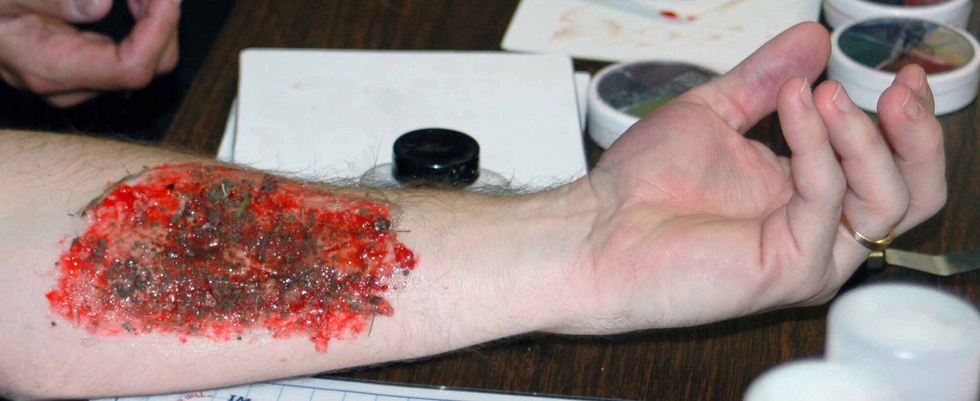 552 Air Control Wing Master Sgt. Ronnie Phillips displays a bloody road rash injury made of latex, fake blood and dirt. (Air Force photo by Kandis West)