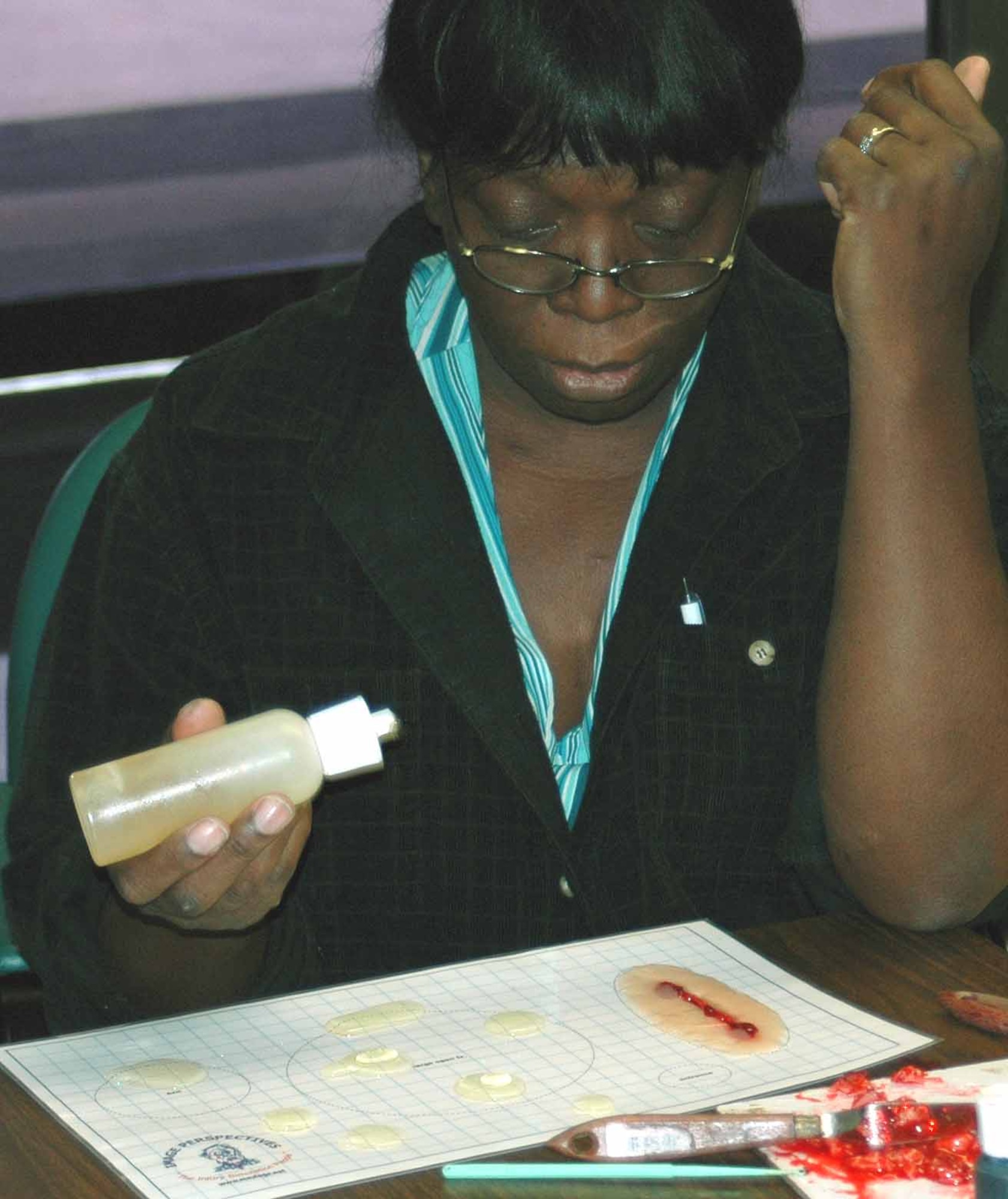 Family Medicine technician Charlen Smith brushes up on her skills by preparing a deep cut on her practice board. She has been a moulage artist for nearly 10 years. (Air Force photo by Kandis West)