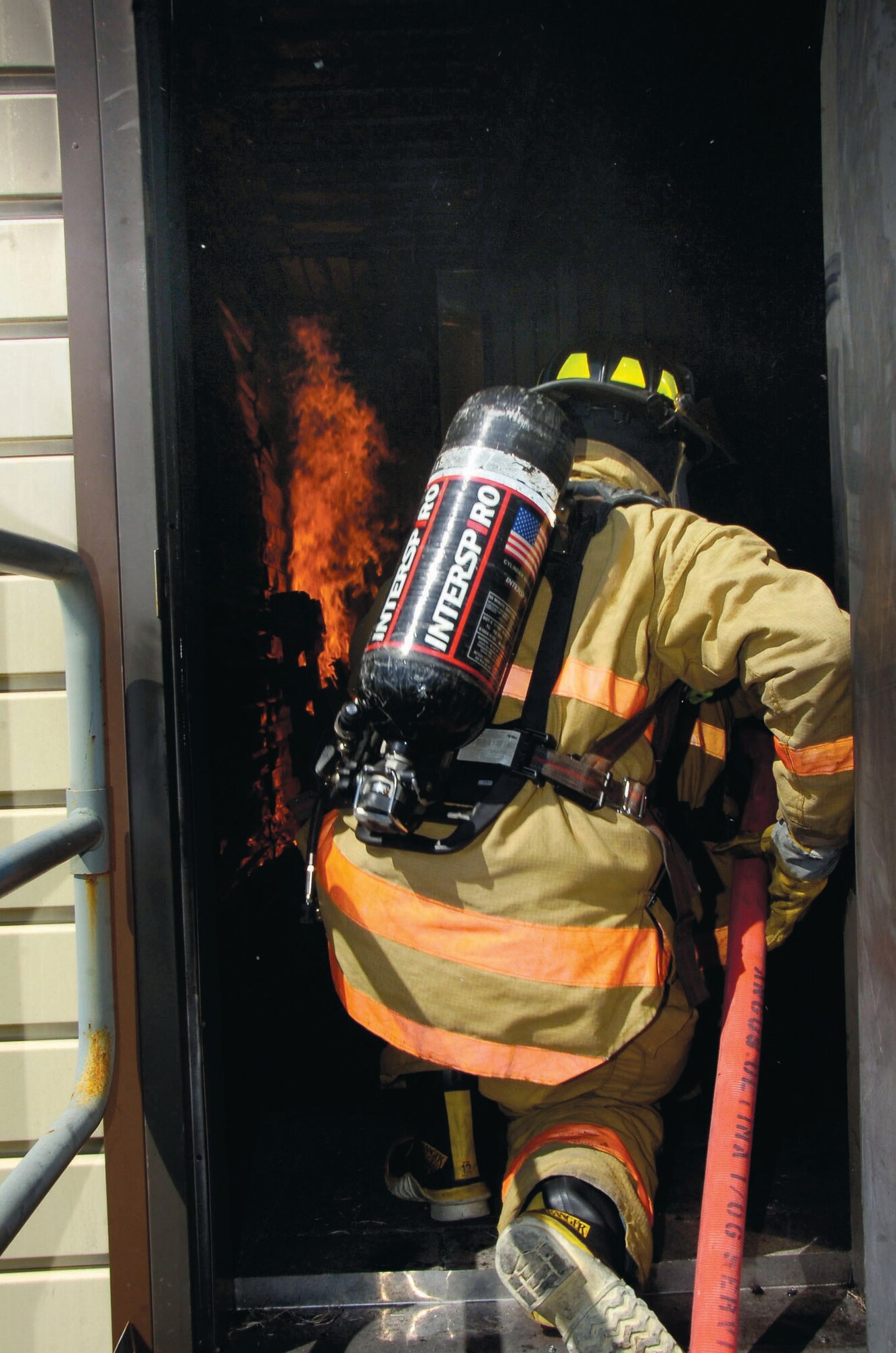 A firefighter enters a simulated burning building during a training scenario Sept. 12. (US Air Force/Bobby Jones)
