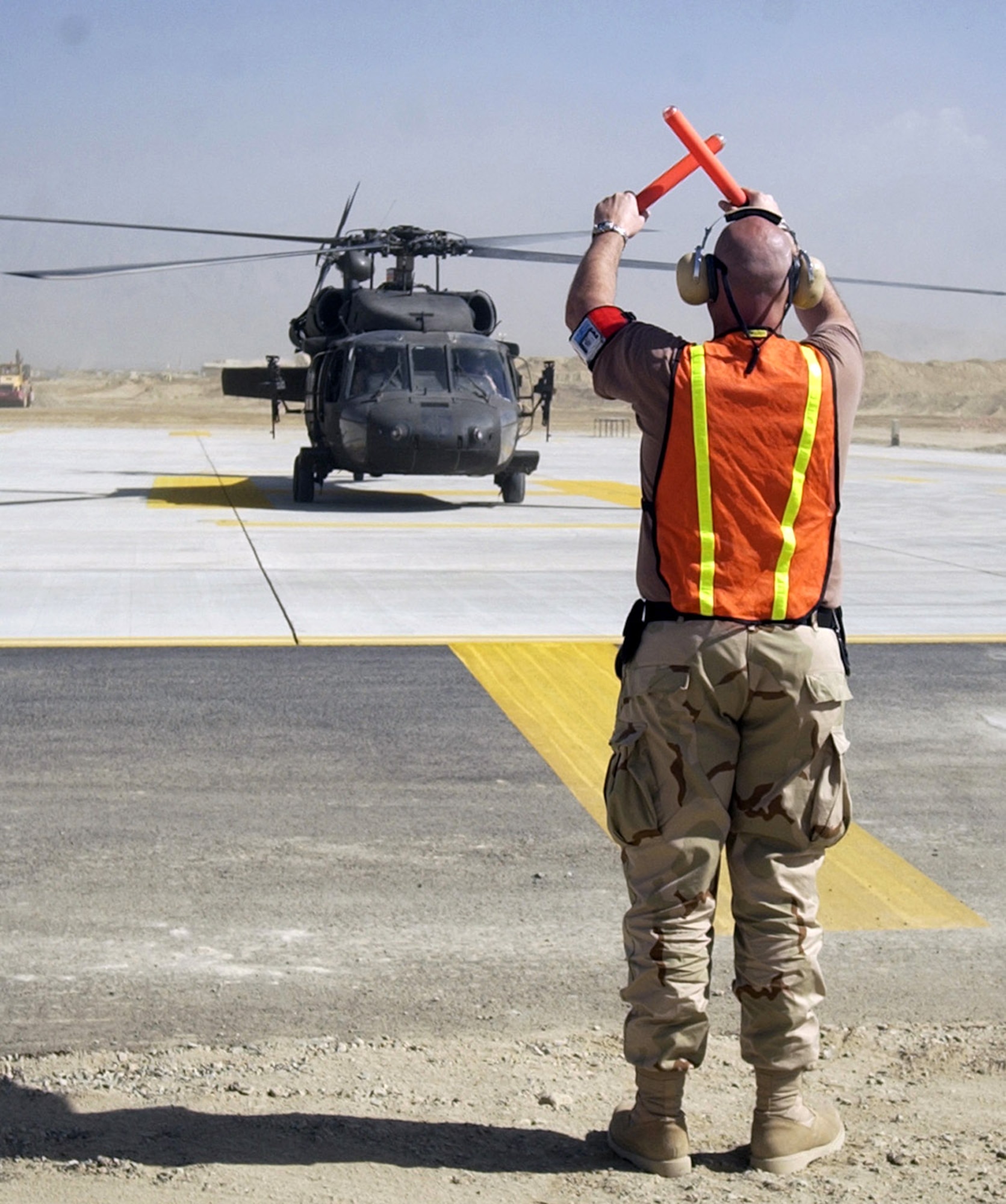 Master Sgt. Jamie Cabral helps land an International Security Assistance Force helicopter on the new ramp Sept. 27 at Bagram Air Base, Afghanistan. The new ramp, one of two new ones officially opened Sept. 27, will bring significant new capability for air support of coalition forces. Sergeant Cabral is a transient alert quality assurance evaluator for the 455th Air Expeditionary Wing. (U.S. Air Force photo/Capt. Michael Meridith)