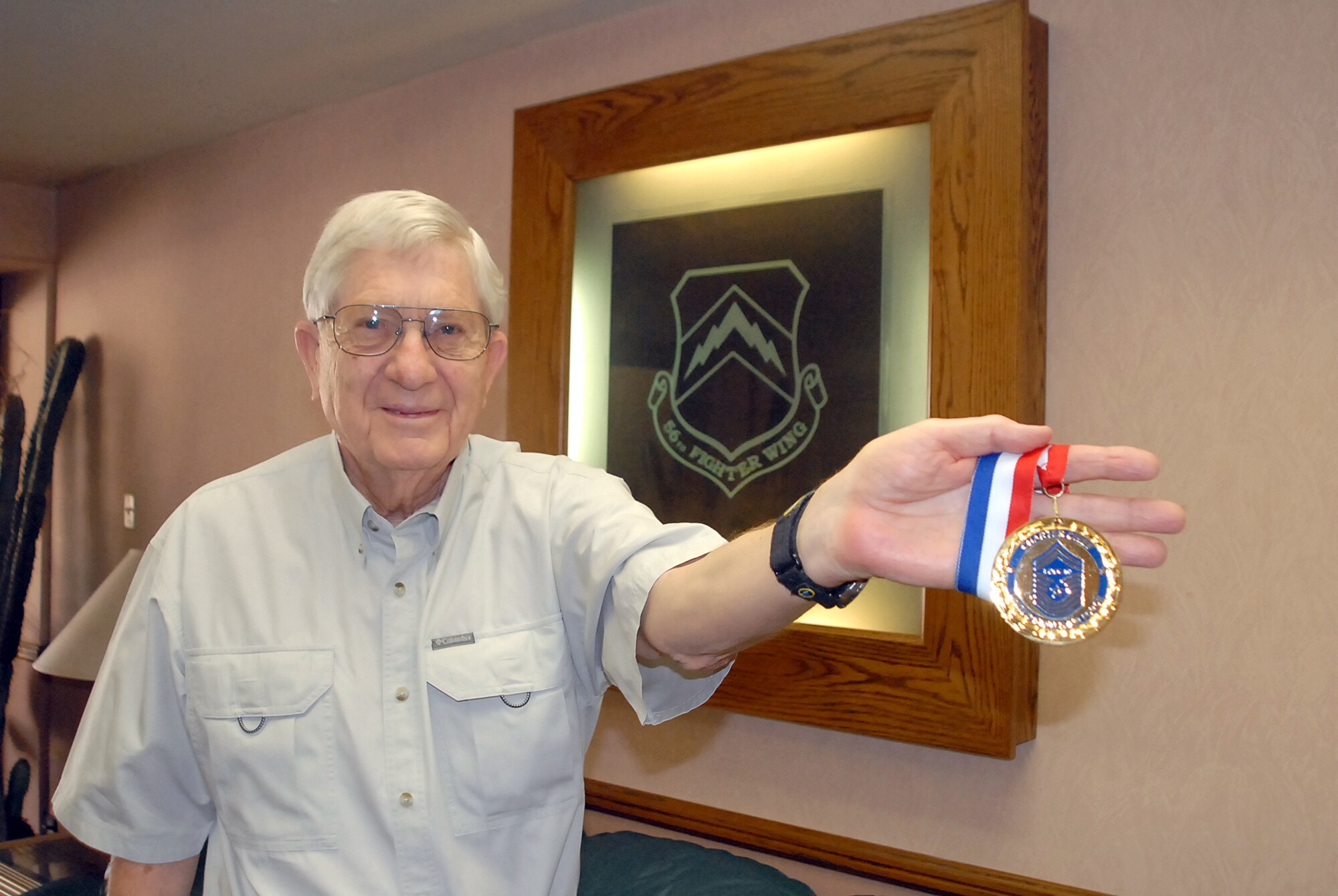 Retired Chief Master Sgt. Wallace Liggett, one of the first-ever chief master sergeants in the Air Force, shows off his Charter Chief medallion which was presented to him after being inducted into the Air Force Heritage Hall of Fame. (photo by 2nd Lt. Bryan Bouchard)