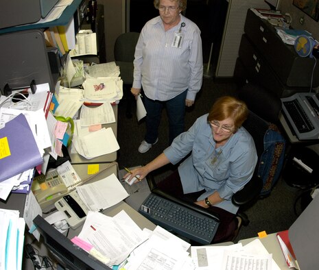 Chris Brown, a financial analyst in ARPC's Directorate of Financial Management, is buried in paperwork, as Finance Technician Janice Safford looks on. Ms. Brown and other FM employees are conducting the annual "end-of-year closeout," when the center's budget is balanced, receipts are tallied and purchases are accounted for much like a personal checking account.