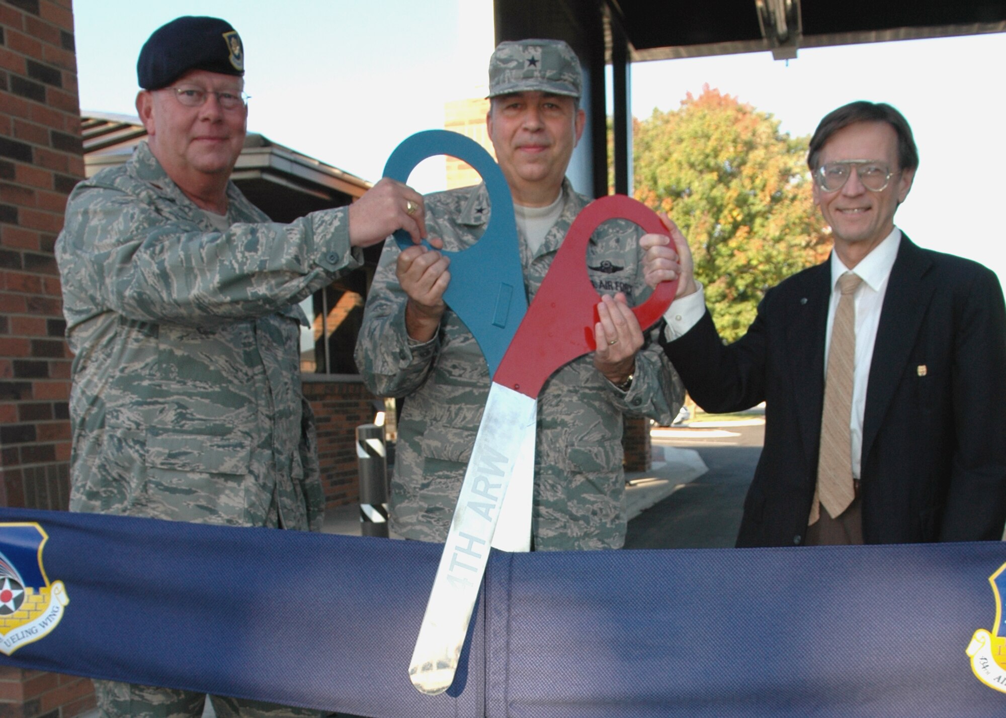 GRISSOM AIR RESERVE BASE, Ind., -- Brig Gen. Dean Despinoy, 434th Air Refueling Wing commander, center, is joined by Maj. Randall Stivers, 434th Security Forces Squadron commander, left, and David Hughes, base civil engineer, as they cut the ribbon officially opening Grissom's renovated main gate on Sept. 28. (U.S. Air Force photo/Tech. Sgt. Doug Hays)