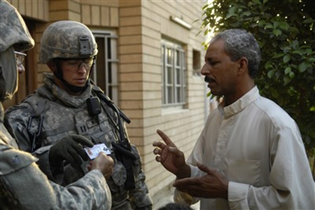 U.S. Army Capt. Brian McCall (2nd from left) talks to a local Iraqi man during a cordon and search mission in Baghdad, Iraq, on Sept. 25, 2007.  McCall is assigned to 2nd Battalion, 32nd Field Artillery Regiment, 4th Brigade Combat Team, 1st Infantry Division.  