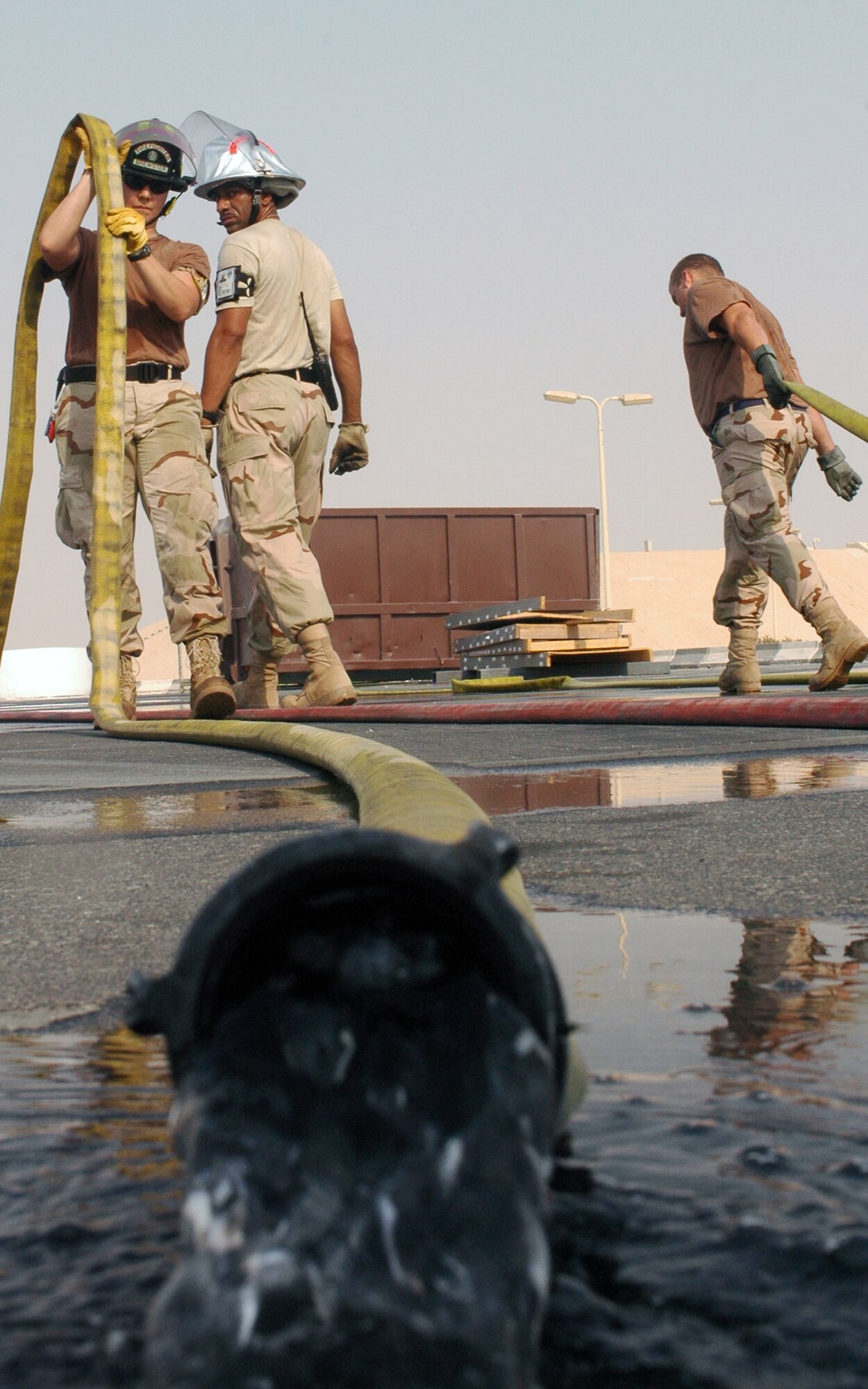 SOUTHWEST ASIA -- Firefighters from the 379th Expeditionary Civil Engineer Squadron roll their hoses up after testing their equipment to ensure they are ready to respond at a moments notice for a real-world emergency. (U.S. Air Force photo/ Staff Sgt. Jason Barebo)