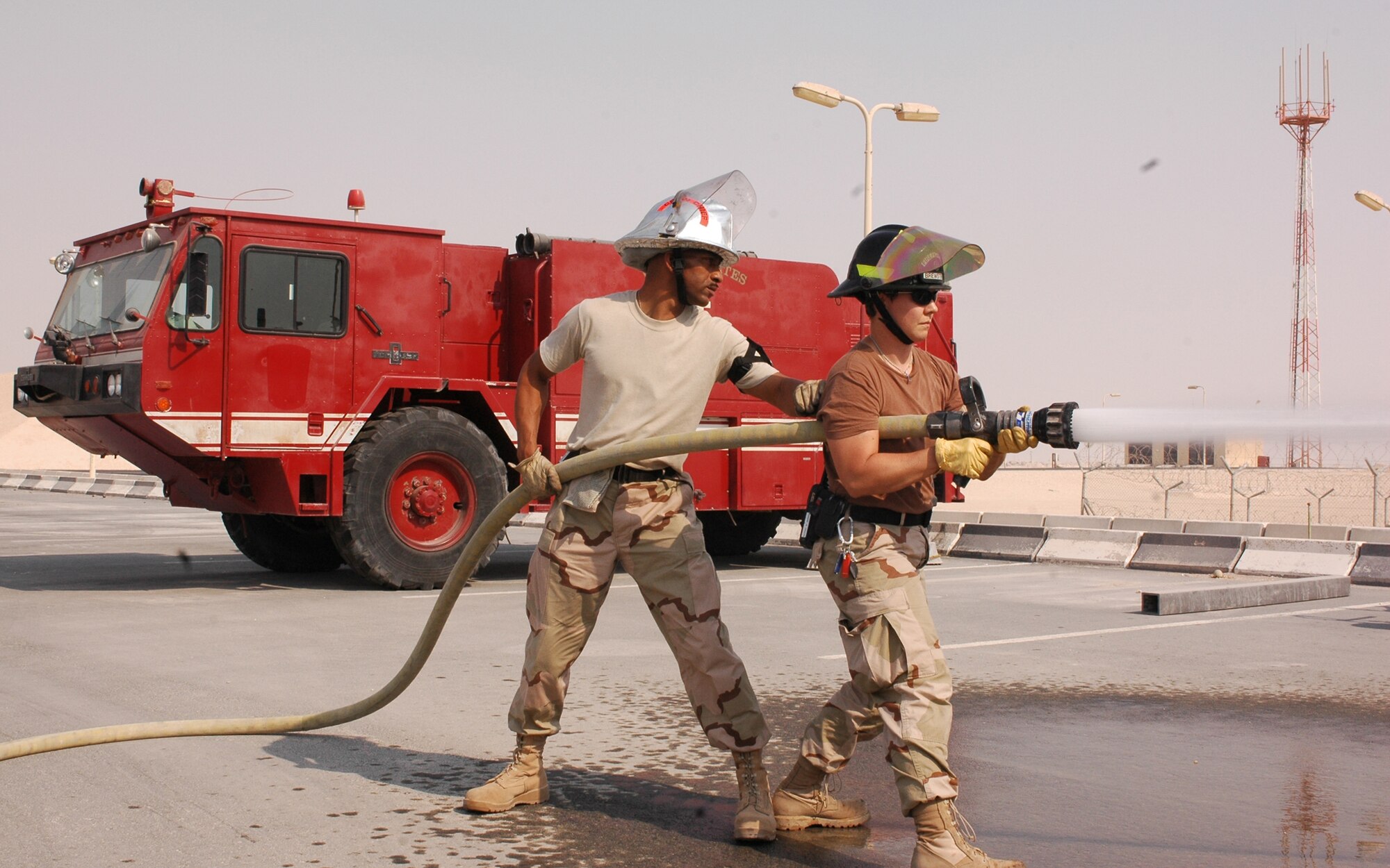 SOUTHWEST ASIA -- Staff Sgt. Charmant Thomas (left) and Staff Sgt. Heather Brewster, 379th Fire Department, perform an operational check a fire hose Wednesday. Operational checks of all equipment and vehicles is necessary to ensure the firefighters’ equipment is ready to be used at a moments notice in the event of a real-world emergency. The 379th Fire Department has three stations located across base to quickly and effectively provide emergency services to the base. (U.S. Air Force photo/ Staff Sgt. Jason Barebo)