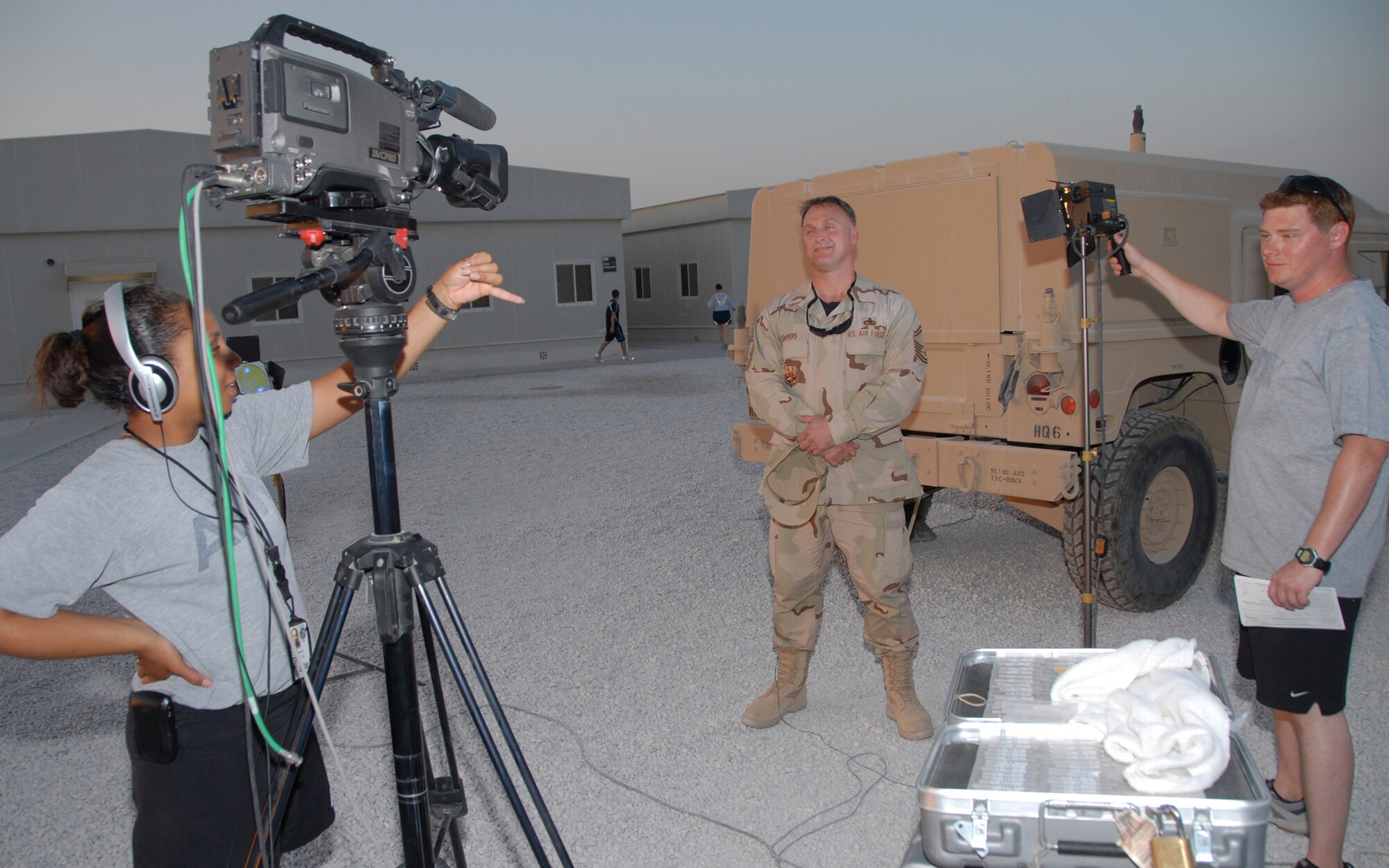 SOUTHWEST ASIA -- Army Sgt. Kim Williams prepares to shoot a Home Town News Holiday Greeting Sept. 22 of Senior Master Sgt. Daniel DeMers who is deployed from Spangdahlem AB to Southwest Asia. Sergeant Williams and a Home Town News team traveling throughout Southwest Asia filmed more than 350 video clips for the upcoming holiday season.  (U.S. Air Force photo/Master Sgt. Greg Kunkle)
