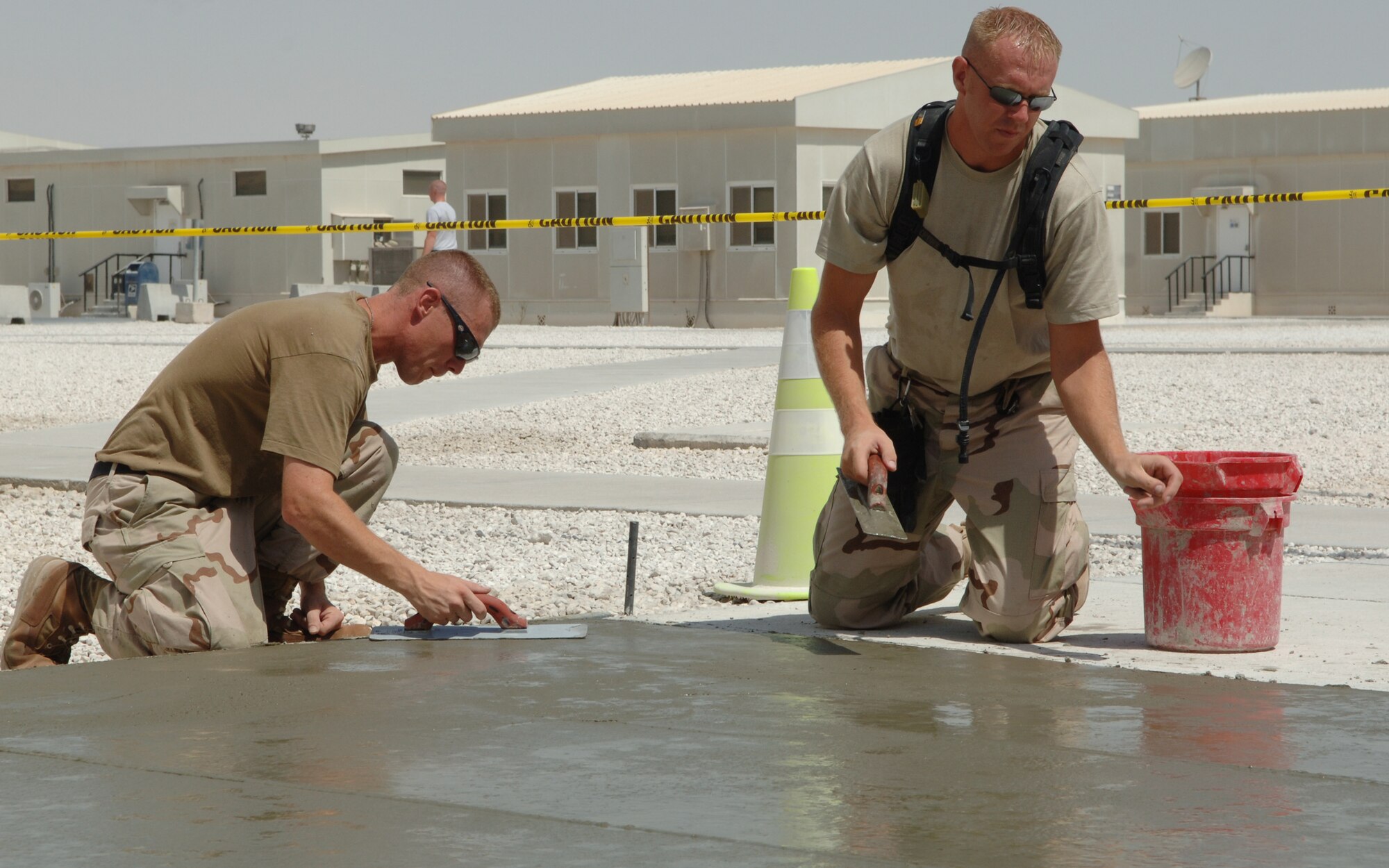 SOUTHWEST ASIA -- Staff Sgt. Mike Shannon of Eielson AFB and Staff Sgt. Brian Barbien of Dyess AFB, both  members of the 379th Expeditionary Civil Engineer Squadron here, put the finishing touches  on a cement slab poured for flight formations and to make the base better for Airman, Sept. 27. (U.S. Air Force photo/Master Sgt. Greg Kunkle)