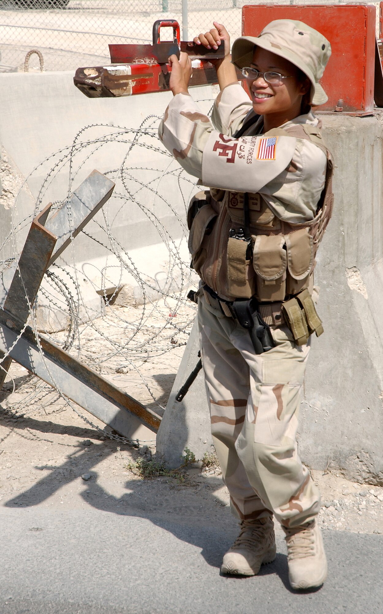 SOUTHWEST ASIA -- Senior Airman Trasy Rincan, 379th Expeditionary Security Forces Squadron, deployed from RAF Mildenhall, United Kingdom, waits for a vehicle to pass before replacing the barrier. (U.S. Air Force photo/Master Sgt. Greg Kunkle)