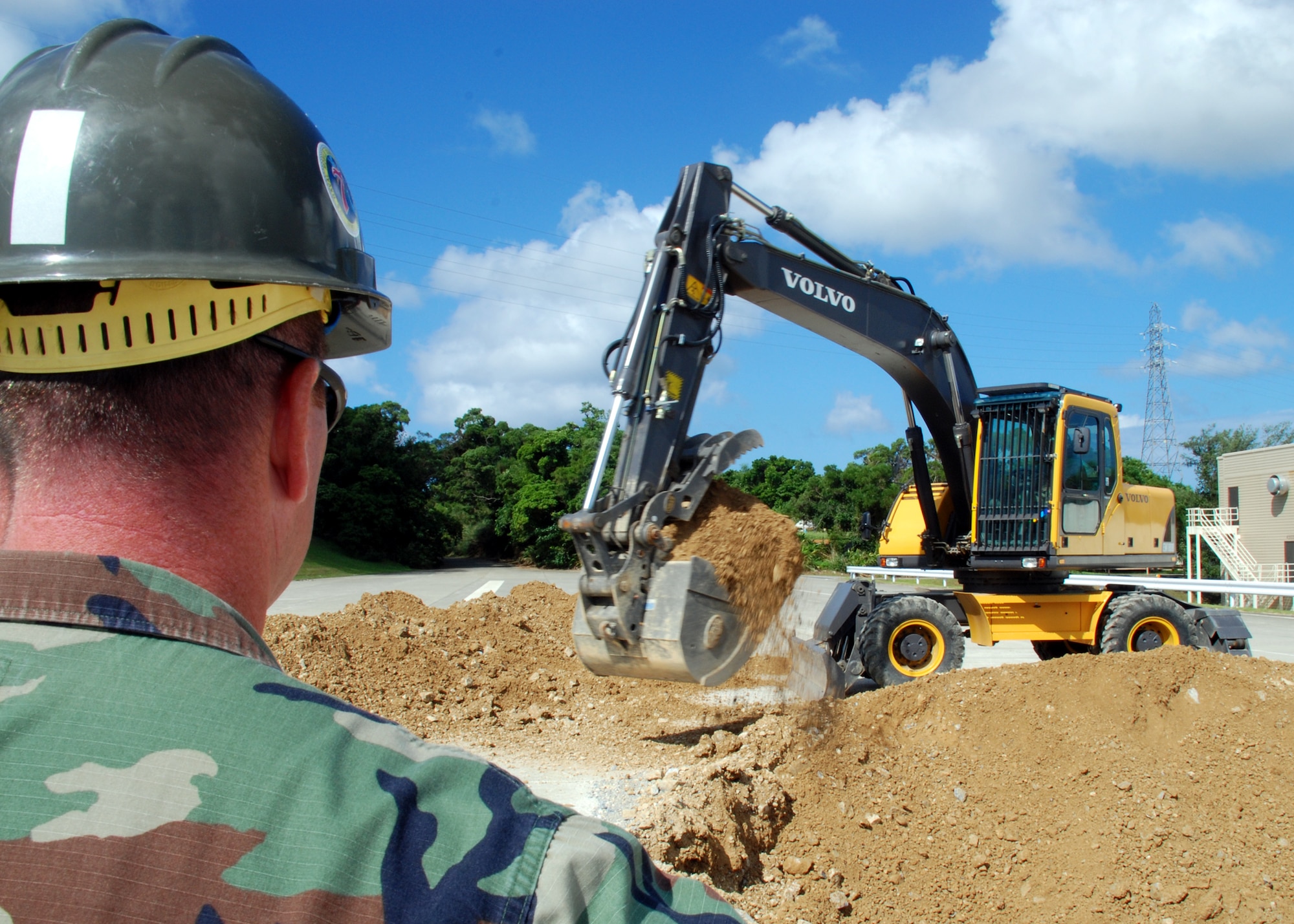 Equipment Operator 1st Class (SCW) David Martin supervises Equipment Operator 1st Class (SCW) Van Johnson as he excavates a crater September 25, 2007 in a simulated runway on Kadena Air Base as part of a joint-training exercise with the U.S. Air Force. 87 Naval Mobile Construction Battalion (NMCB) 7 personnel experienced the Rapid Runway Repair (RRR) training led by Kadena airmen to teach Seabees critical skills for their next deployment. NMCB 7 is currently deployed to the Far East to provide construction support to shore installations in support of the global war on terrorism.  (U.S. Navy photo/Mass Communication Specialist 2nd Class Michael B. Lavender )