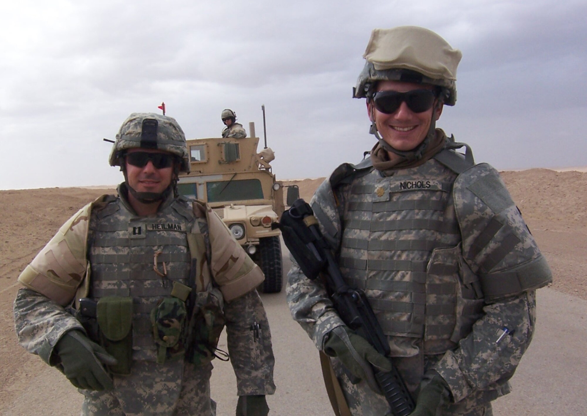 Maj. Paul Nichols and a fellow captain pose in front of their armored vehicle in Iraq recently.  Major Nichols is deployed  as part of the 264th Combat Support Sustainment Battalion in al Taqaddum, Iraq.  The major is deployed from the 961st Airborne Air Control Squadron at Kadena Air Base, Japan.  (Courtesy photo)