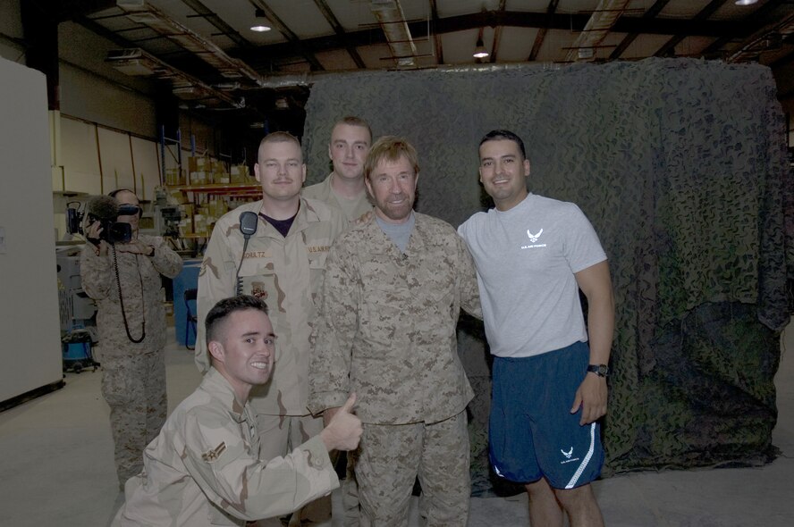 Airman 1st Class Sean Harris (front kneeling) and other deployed Airmen meet actor and military supporter Chuck Norris during a recent visit to Southwest Asia.  Airman Harris is deployed from the 18th Security Forces Squadron at Kadena Air Base, Japan.  (U.S. Air Force courtesy photo)