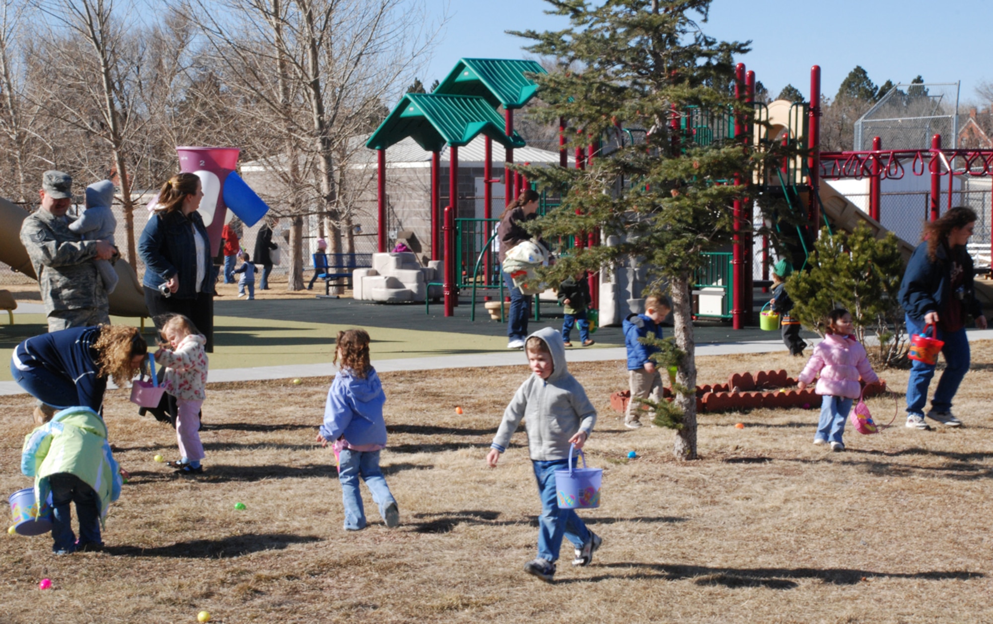 Children run to collect the Easter eggs during the hunt at the youth center playground (U.S. Air Force photo/Staff Sgt. Chad Thompson).