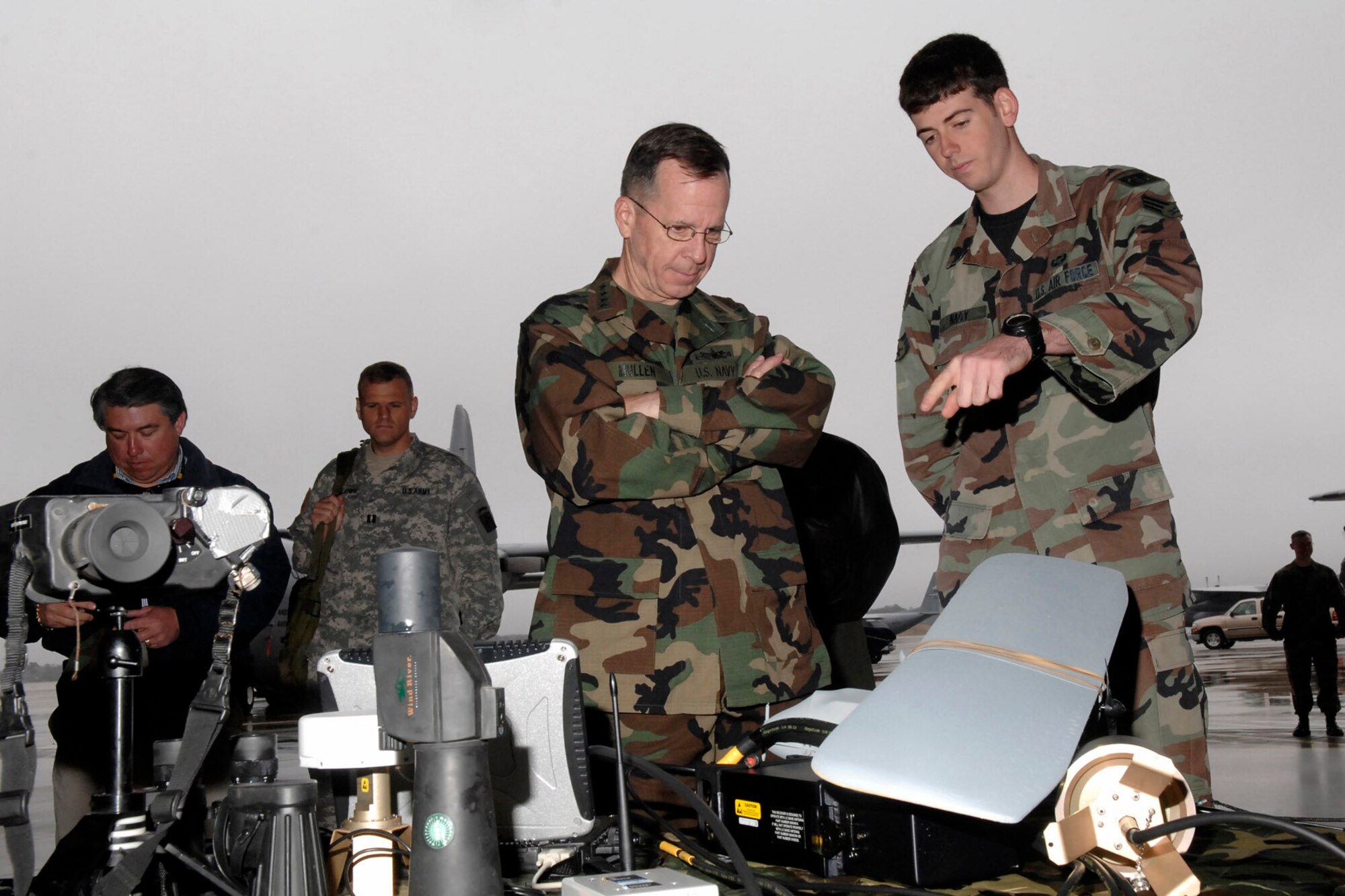 Senior Airman Aaron Nagy, from the 14th Air Support Operations Squadron, shows Adm. Mike Mullen, chairman of the Joint Chiefs of Staff, some of the equipment used by a tactical air control party Airman during the admiral's tour of Pope Air Force Base, N.C., March 31.  The admiral also toured nearby Fort Bragg during his visit.  (U.S. Air Force photo/Mike Murchison)