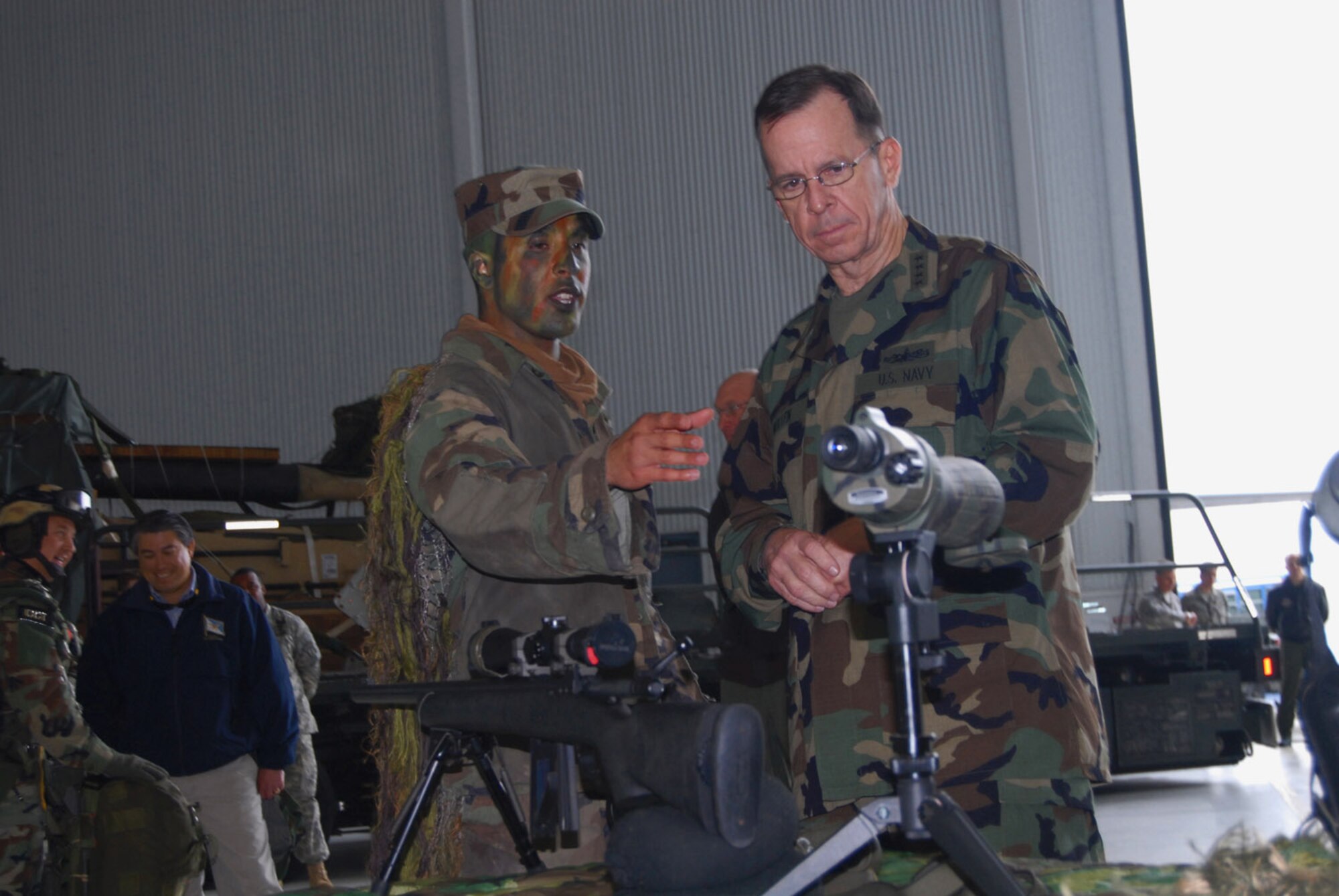Staff Sgt. Yamil Roman-Rivera, a 43rd Security Forces Squadron Airman, gives a sniper rifle presentation March 31 to Adm. Mike Mullen, chairman of the Joint Chiefs of Staff, during his visit to Pope Air Force Base, N.C. and nearby Fort Bragg.  Airmen from the 43rd SFS also had a military working dog presentation at the expo. (U.S. Air Force photo/Airman 1st Class Mindy Bloem)
