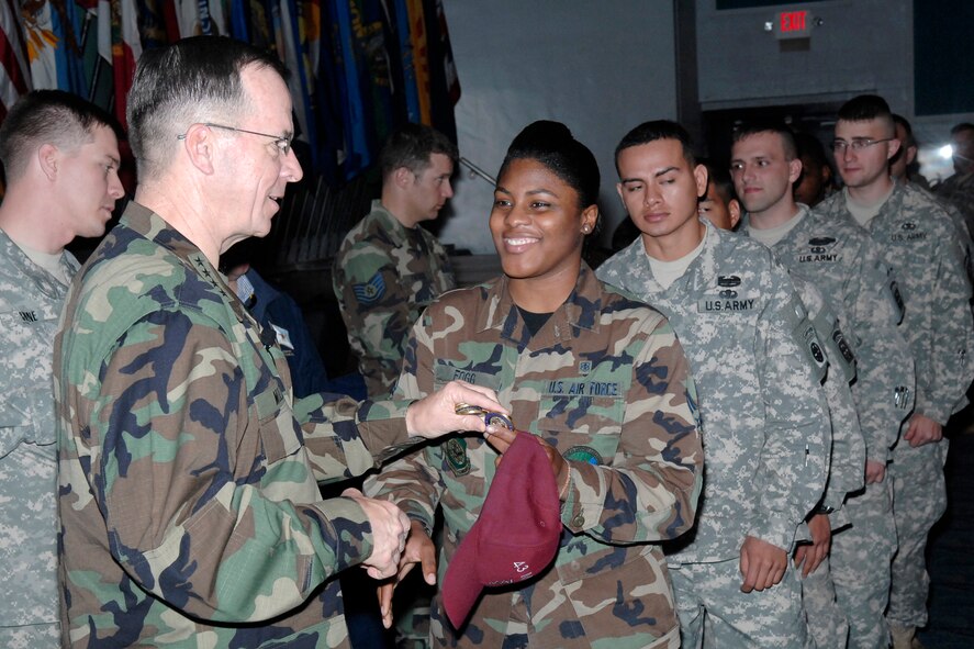 Senior Airman Lateesha Fogg, 43rd Medical Support Squadron, receives a coin from Adm. Mike Mullen, Chairman of the Joint Chiefs of Staff, Monday in the Pope Theatre. Admiral Mullen spoke to more than 300 Airmen and Soldiers and presented anyone who wanted his coin with one after the question and answer period. Admiral Mullen visited Pope and Ft. Bragg for the first time since he assumed command in October 2007. (U.S. Air Force Photo by Mike Murchison)