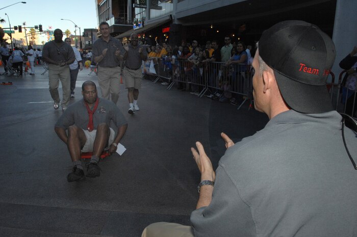 LAS VEGAS -- Chief Master Sgt. Robert Brooks (foreground), 99th Air Base Wing command chiief, cheers on Lt. Col. Ronald Coleman, 99th Mission Support Group deputy commander during the Las Vegas Corporate Challenge executive relay March 26. Team Nellis placed sixth in the executive relay event with a time of three minutes and 40 seconds. (U.S. Air Force Photo/Senior Airman Larry E. Reid Jr.)