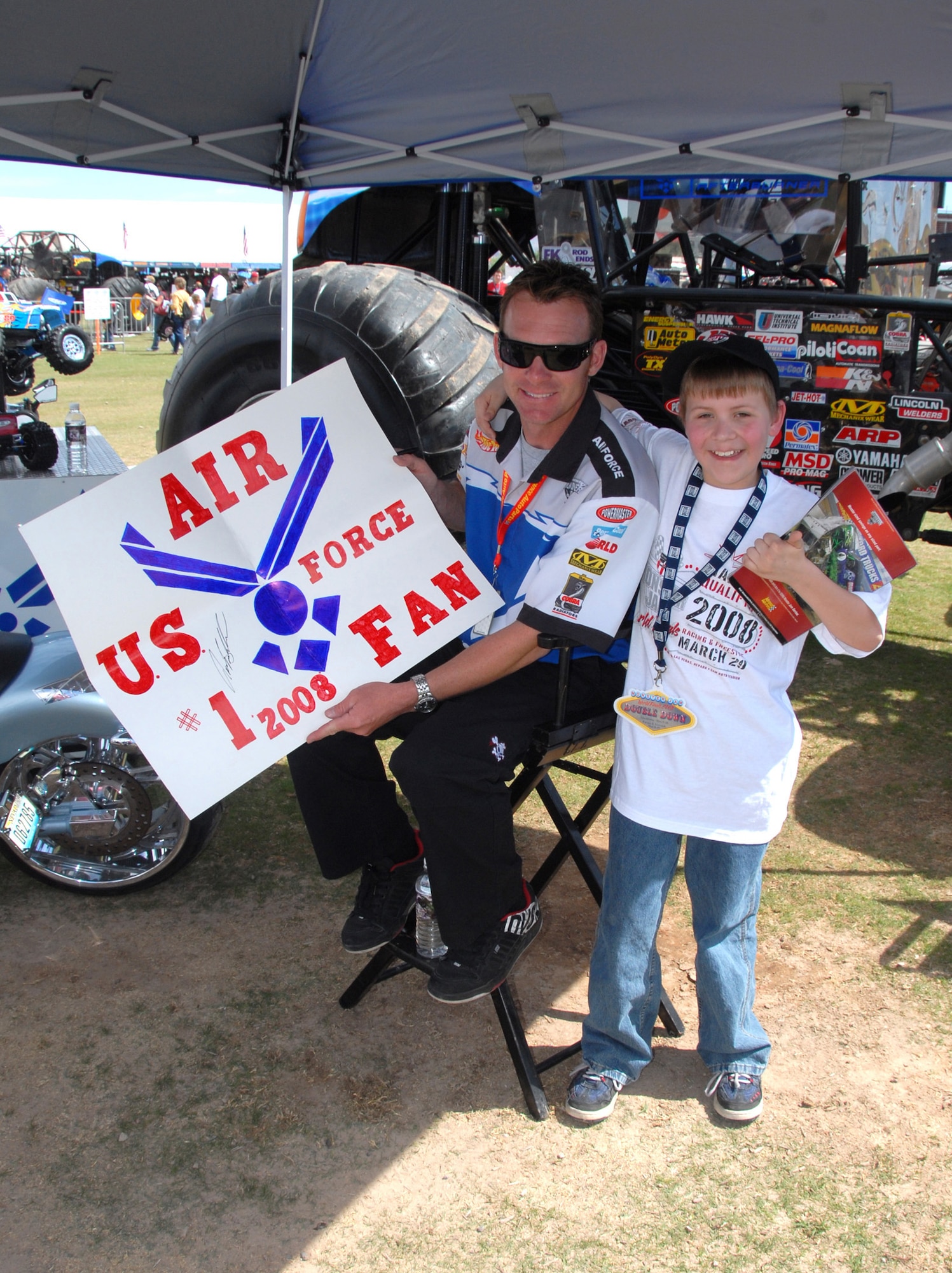LAS VEGAS -- Damon Bradshaw, driver of the Air Force Afterburner monster truck, greets his ?#1 Fan? during an autograph session on March 29.  Mr. Bradshaw and Afterburner were in Las Vegas to compete in the Monster Jam monster truck world finals.  Nellis AFB provided  an Honor Guard and a 50-Airman formation carrying state flags at the event. (U.S. Air Force photo/Chief Master Sgt. Gary Emery)