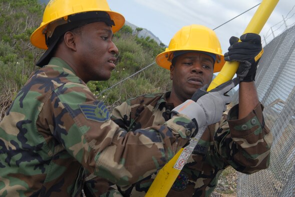 VANDENBERG AIR FORCE BASE, Calif. , --
Staff. Sgt. Benjamin White and Staff. Sgt. David Lewis, both members of the 30th Civil Engineer Squadron, utilize an extend-o - stick to shut off the power source of a building in the process of being upgraded on April 1. (U.S. Air Force Photo / SrA Christopher Hubenthal)
