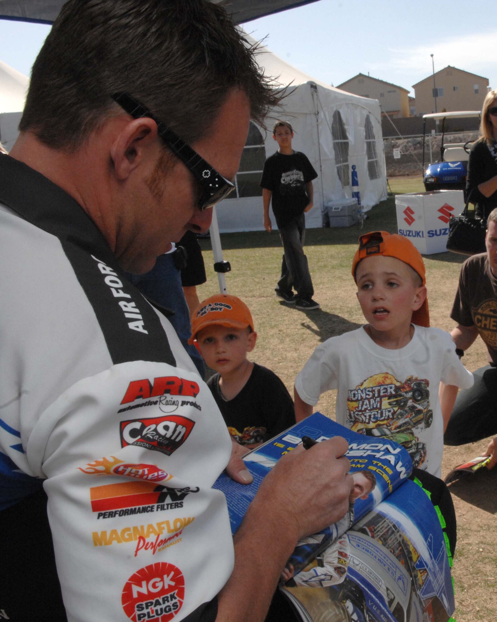 Damon Bradshaw, driver of the U.S. Air Force Afterburner monster truck, autograph a young fans event program during a meet and greet session at the Monster Jam World Finals in Las Vegas, Nev., March 29, 2008. 
(U.S. Air Force Photo by/Senior Airman Larry E. Reid Jr.)
(Released)