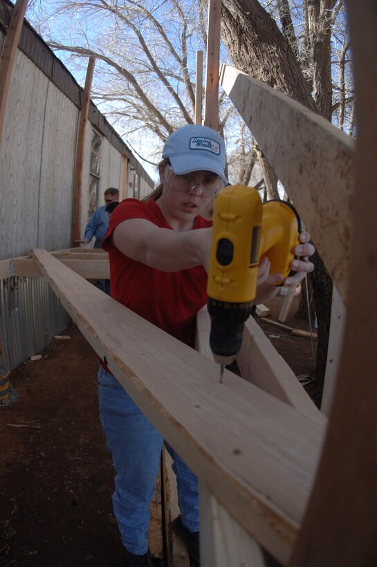 Air Force Academy Cadet 2nd Class Nicole Ramstein secures a screw on a porch during a volunteer build March 26 in Navajo, N.M. Cadet Ramstein along with a group of 20 cadets, faculty and family members, volunteered to work on the Navajo reservation during the Academy's spring break. (U.S. Air Force photo/John Van Winkle)