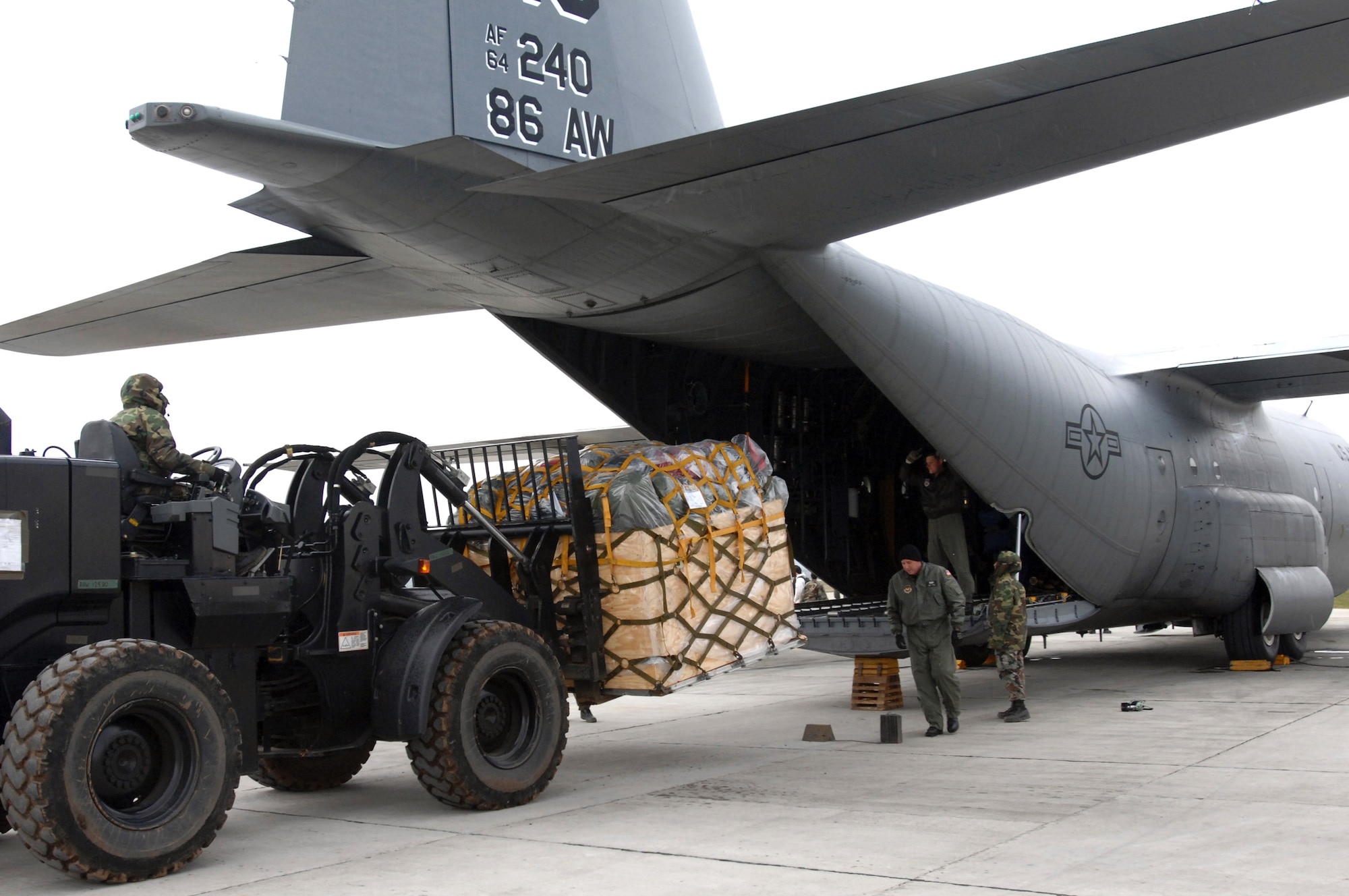 Airmen from the 404th Expeditionary Air Base Squadron unload pallets from a 86th Airlift Wing C-130 Hercules dropping off cargo and personnel here March 25. A four-man team of Airmen received and processed more than 500,000 pounds of cargo here toward building up U.S. operations at the base in support of the NATO summit. The U.S forces are augmenting NATO by providing infrastructure and aircraft for the duration of summit in Bucharest, Romania, April 2-4. (U.S. Air Force photo/Senior Airman Teresa M. Hawkins)