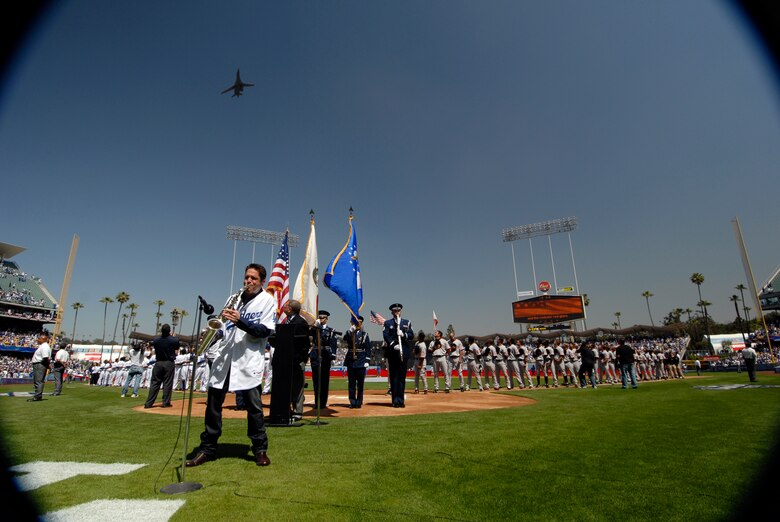LOS ANGELES, Calif. -- Airmen in the Vandenberg Air Force Base Honor Guard post the colors while jazz saxophonist Dave Koz plays the national anthem and a B-1 bomber makes a flyover during opening day festivities prior to start of the San Francisco Giants and Los Angeles Dodgers baseball game here March 31. The Dodgers celebrated the 50th anniversary of their move from New York with a 5-0 win over the Giants in their season opener. (U.S. Air Force photo/Airman 1st Class Christian Thomas)