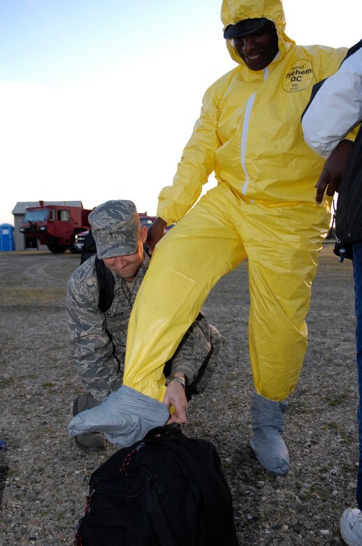 VANDENBERG AIR FORCE BASE, Calif. -- Chaplain (Capt.) Matthew Clouse assists Master Sgt. Keith Maddox, 30th Medical Group, with donning a biological and chemical protection suit during a Foggy Shores Exercise scenario here March 25. (U.S. Air Force photo/Staff Sgt. Angelique Perez)