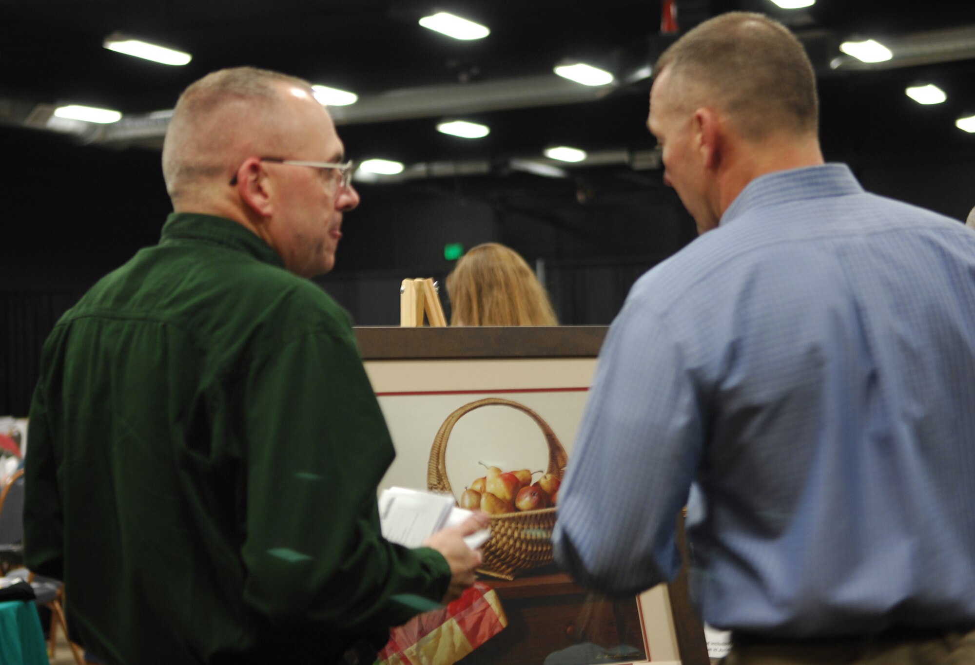 MINOT AIR FORCE BASE, N.D. -- Chief Master Sgt. Mark Clark (left), 5th Bomb Wing command chief, and Chief Master Sgt. Mark Brechja, 91st Space Wing command chief, look at a still-life painting of pears to be auctioned during the 22nd annual Prairie Warrior Association Auction March 29 at the Holiday Inn in Minot. The auction raised almost $35,000 for 5th Bomb Wing and 91st Space Wing units. (U.S. Air Force photo by Maj. Elizabeth Ortiz)