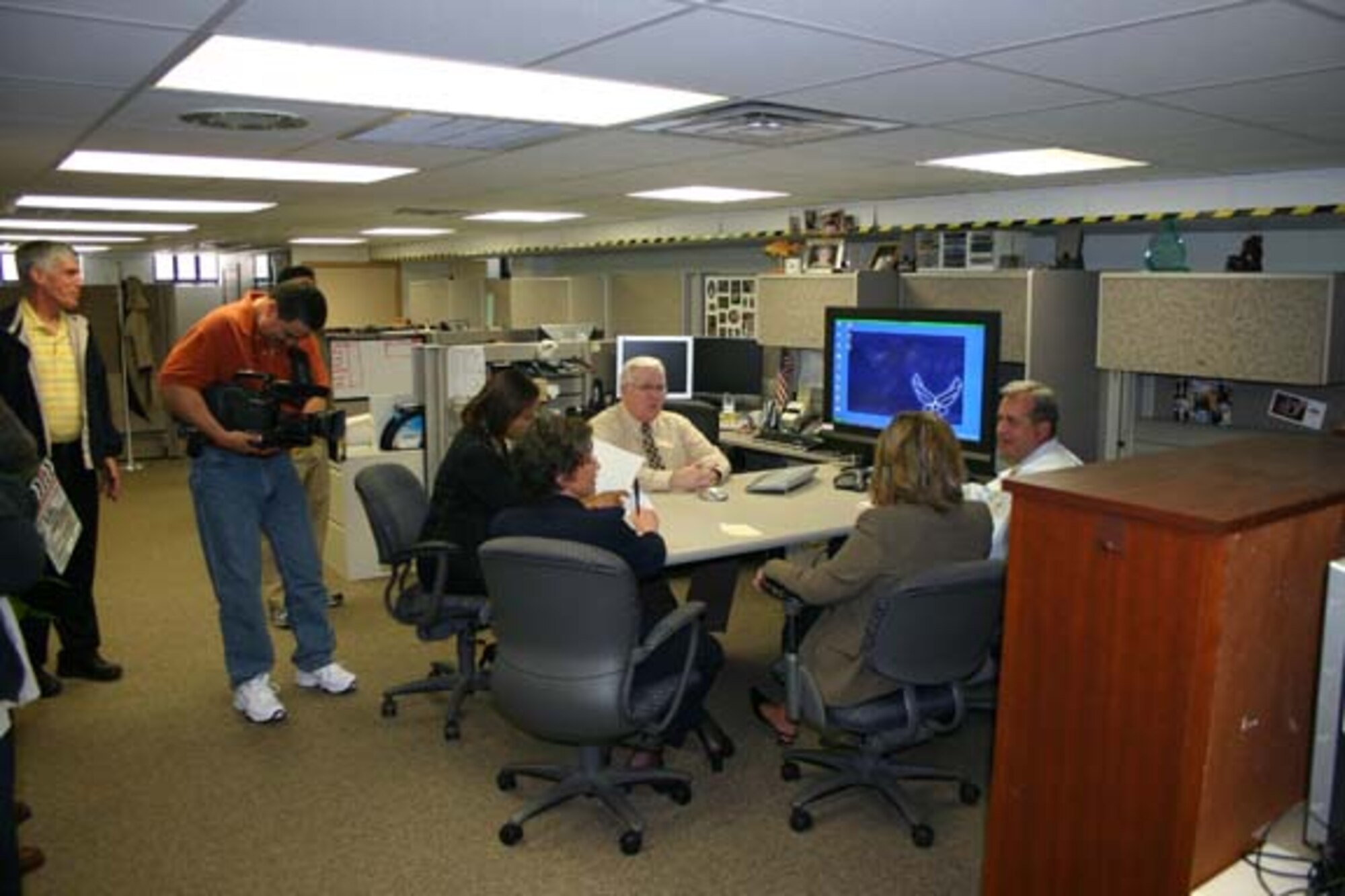 Fred Chapa, videographer from the Air Force Services Agency in San Antonio, films members of the Airman, Family and Community Operations Branch at the Air Force Personnel Center as they discuss a PowerPoint presentation. John Beckett from the Air Force Wounded Warrior Office in the Pentagon, looks on. The film will be used in two training videos to be released in June. (U.S. Air Force photo/Steve VanWert) 