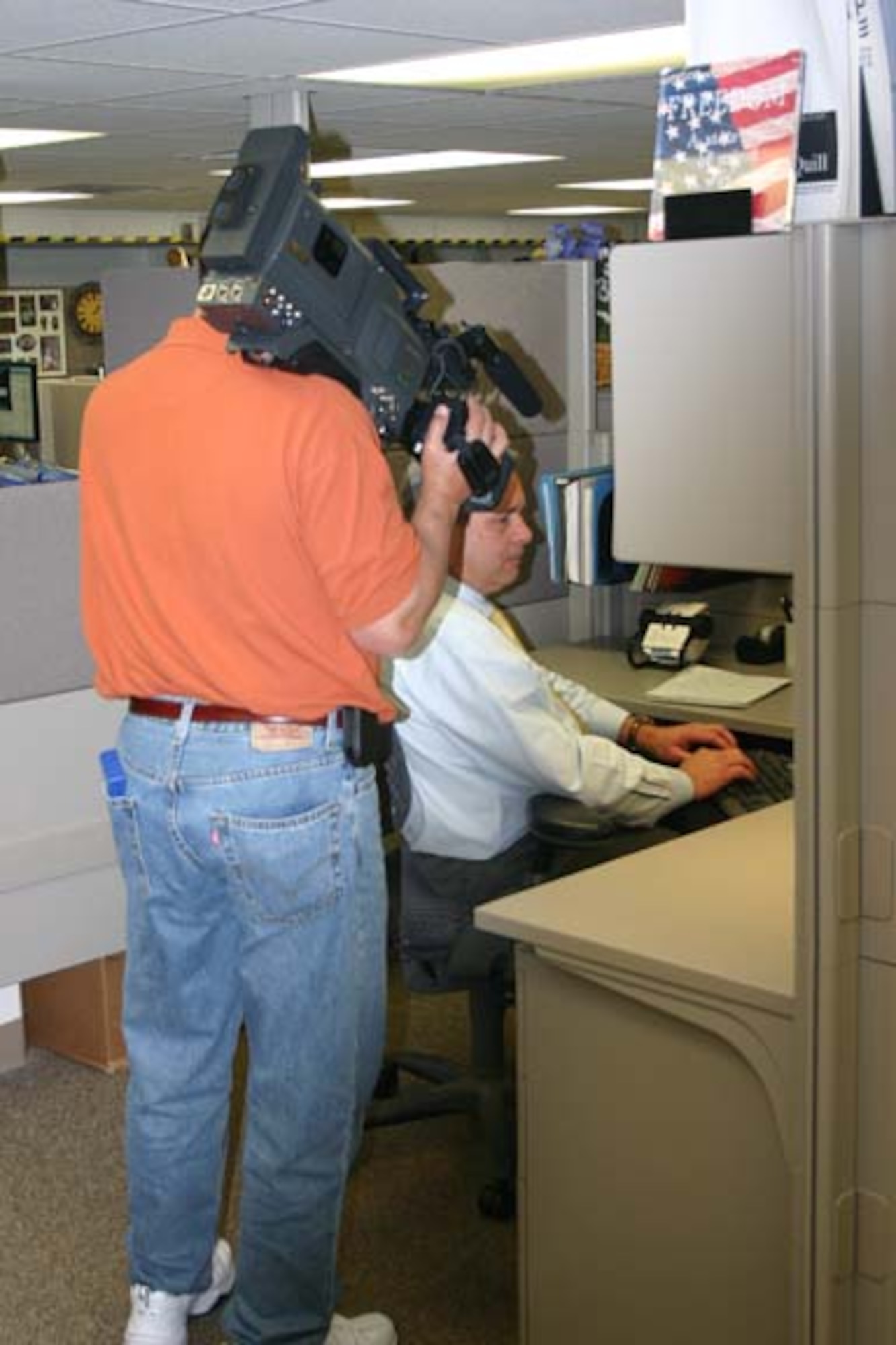 Videographer Fred Chapa from the Air Force Services Agency in San Antonio, films Scott Hand, Air Force Personnel Center Airman, Family and Community Operations Branch, at work. The film is being used in two different training videos for the Family Liaison Officer program. (U.S. Air Force photo/Steve VanWert)