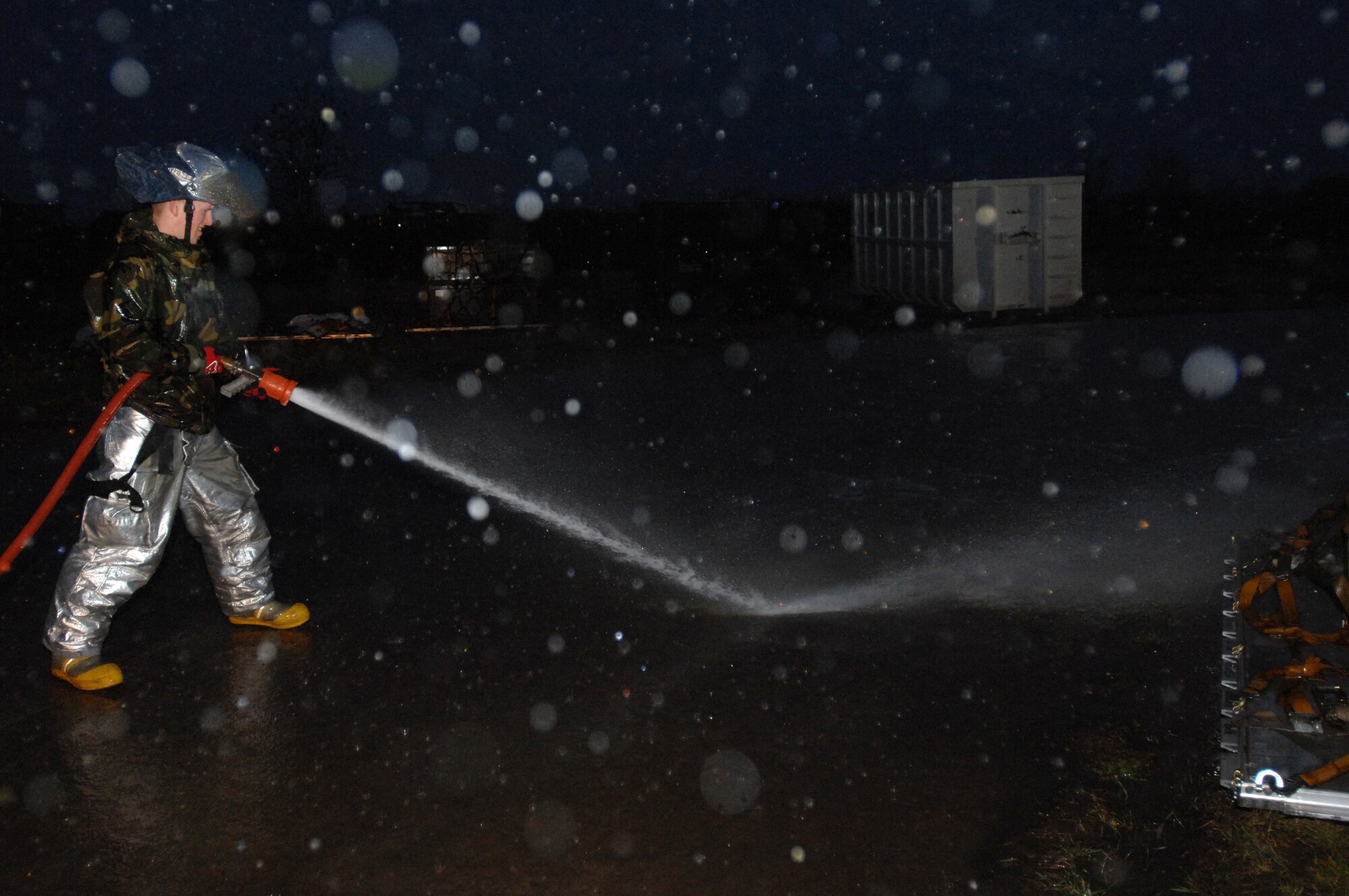 CAMPIA TURZII, Romania -- Airman First Class David Rogan, 404th Expeditionary Air Base Squadron firefighter, blasts dirt off of the road here March 28, 2008. U.S. Air Forces in Europe Airmen deployed here and other locations to conduct operations augmenting NATO forces in providing air security for the Bucharest NATO Summit April 2-4.  The U.S is providing infrastructure, aircraft and personnel to the effort.    (U.S. Air Force photo by Senior Airman Teresa M. Hawkins)