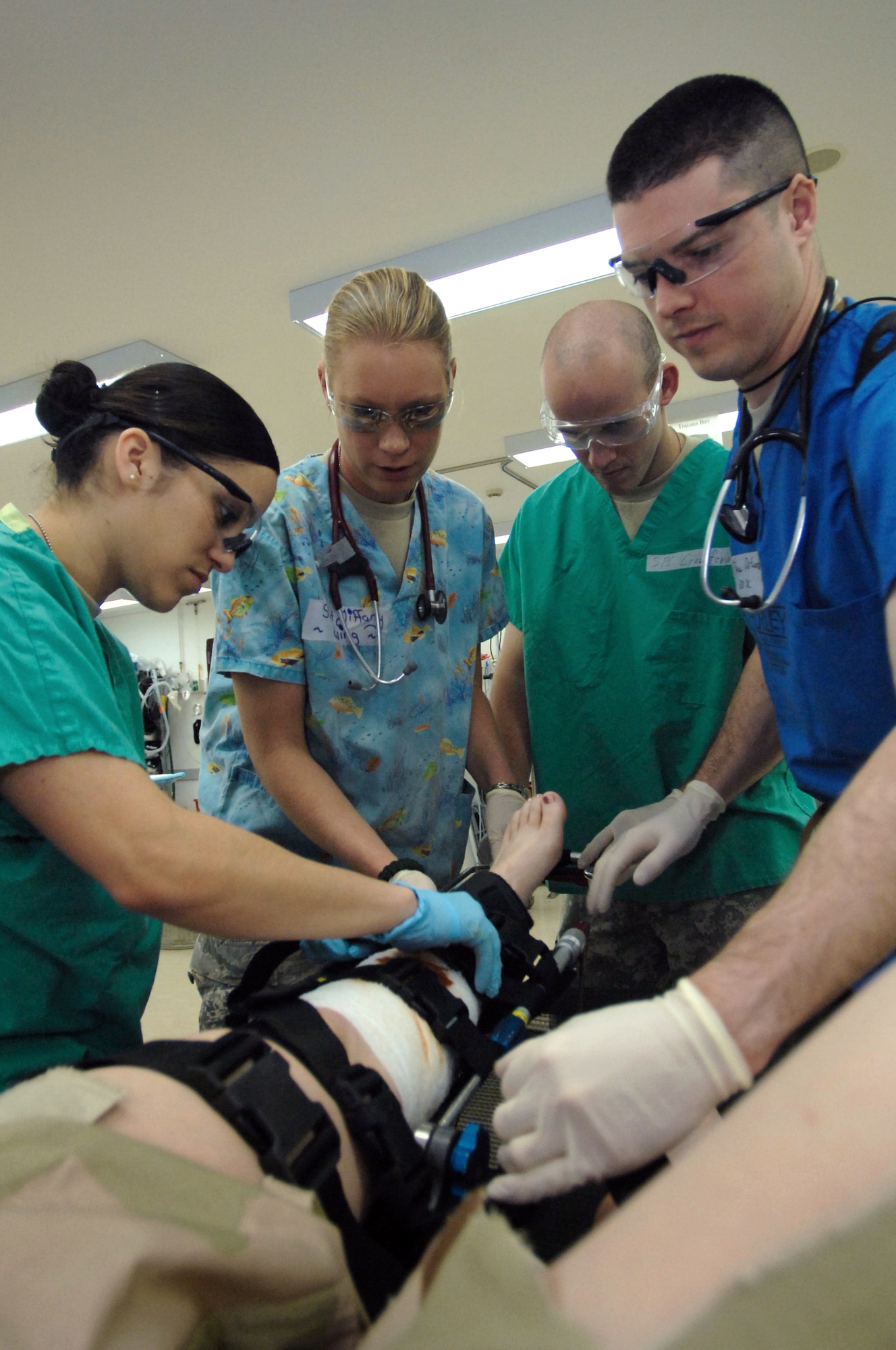 Medical technicians and doctors at the Air Force Theater Hospital emergency room work to stabilize a "patient's" leg injury with a traction splint March 8 at Balad Air Base, Iraq. The emergency room staff provides patients with initial critical care and evaluates the next course of action for each trauma patient. As a whole, the 332nd Expeditionary Medical Group delivers full-spectrum care to Department of Defense beneficiaries, coalition partners and several injured host-nation patients. The staff shown belongs to the 332nd Expeditionary Medical Operations Squadron. The photo is taken from the patient's perspective. (U.S. Air Force photo/ Senior Airman Julianne Showalter) 